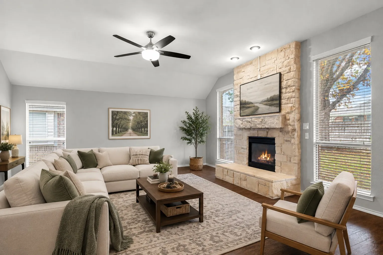 Stone-clad fireplace with hearth, wood-finish flooring, vaulted ceiling, recessed lighting, and ceiling fan with integrated light