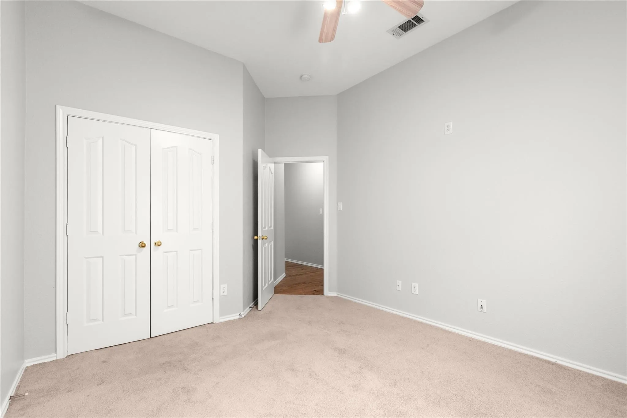 Recessed ceiling with an overhead light fixture, light neutral wall paint, and soft carpet flooring