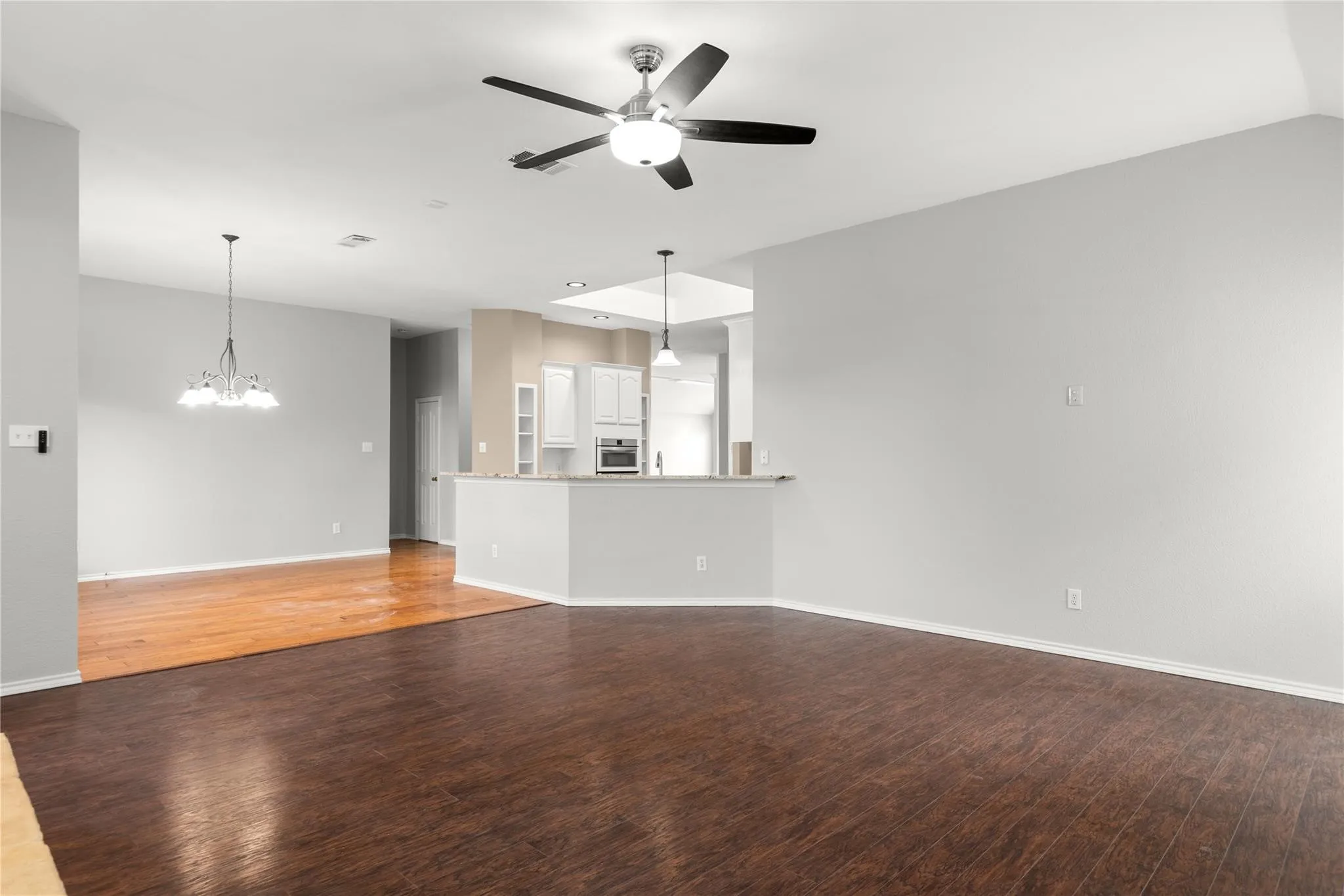 Spacious open-concept living area with dark wood-finish flooring