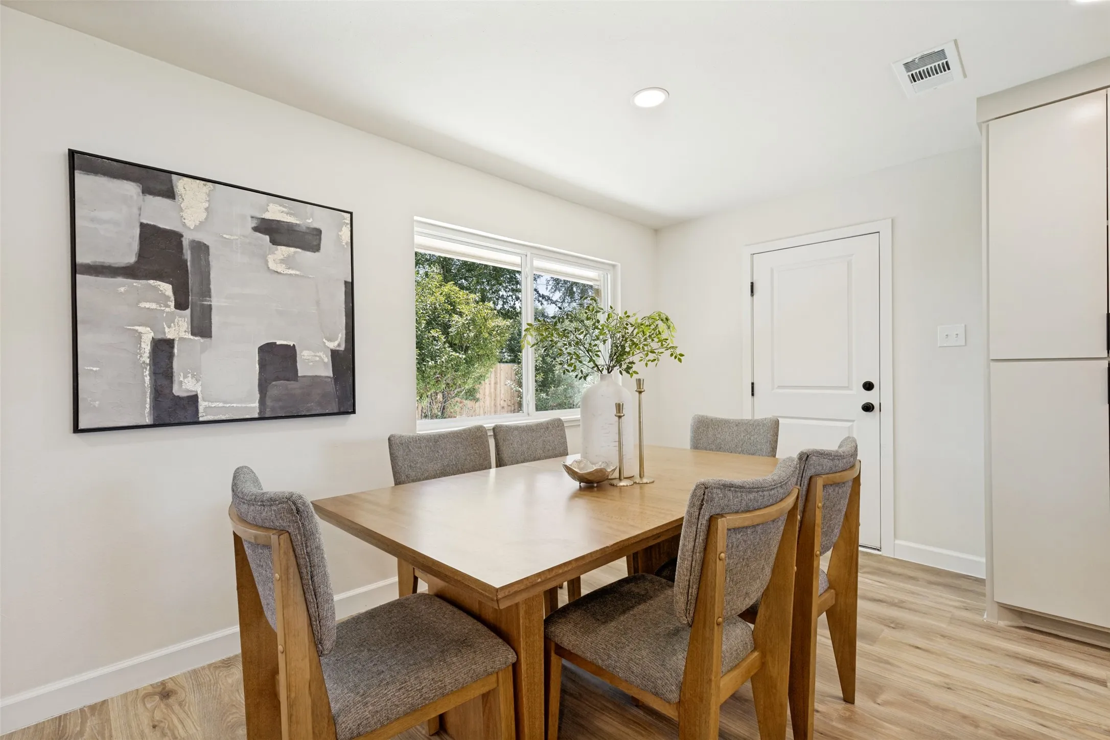 Recessed lighting, wood-finish flooring, white paneled door, and a horizontal window