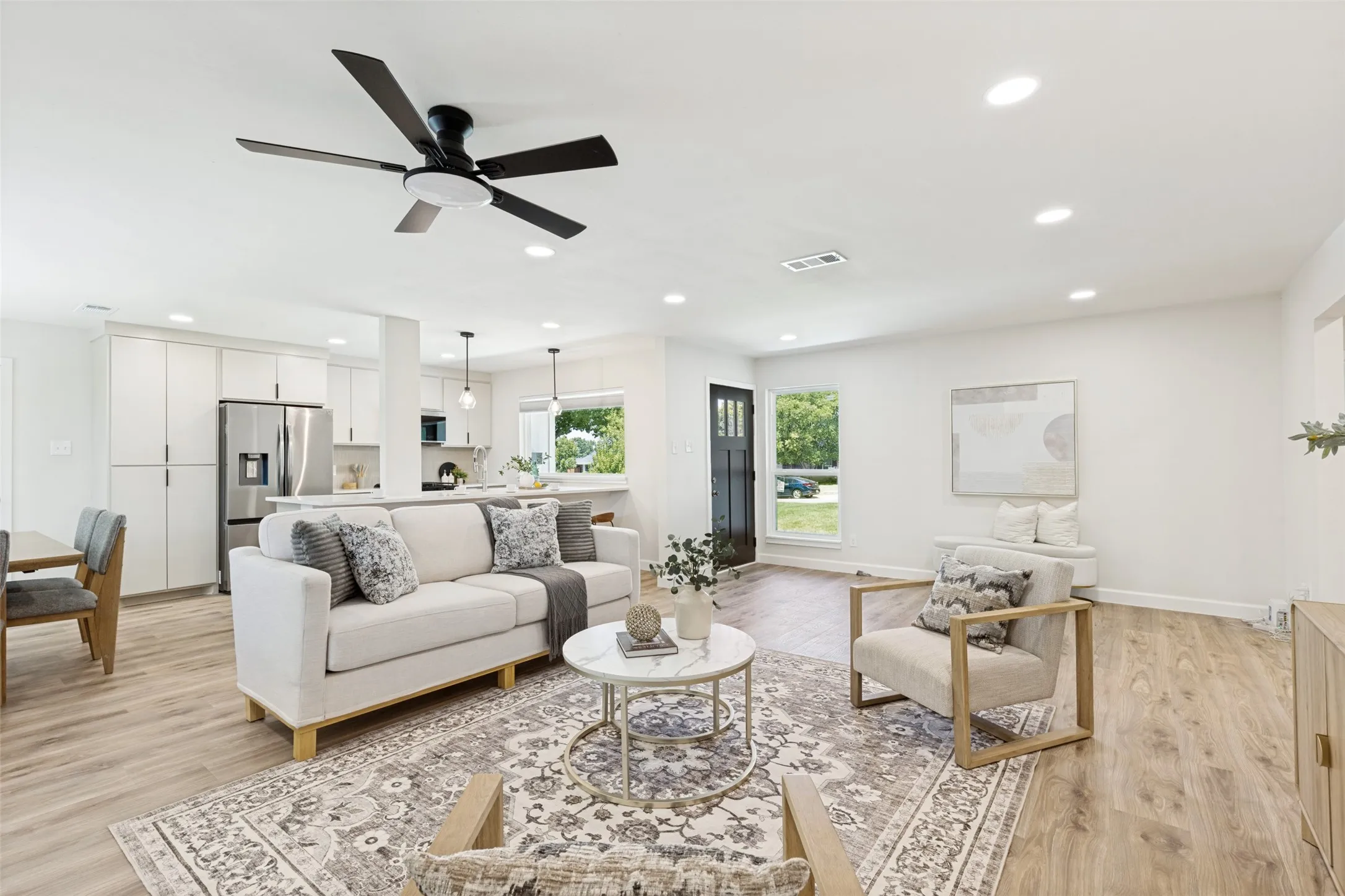 Open-concept living space featuring wood-finish flooring, recessed lighting, and a modern ceiling fan