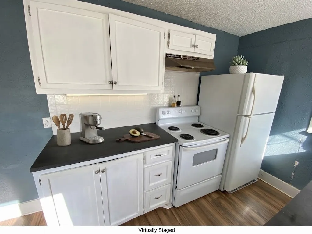 White cabinetry with brushed nickel hardware, solid surface countertops, white tile backsplash, and wood-finish flooring