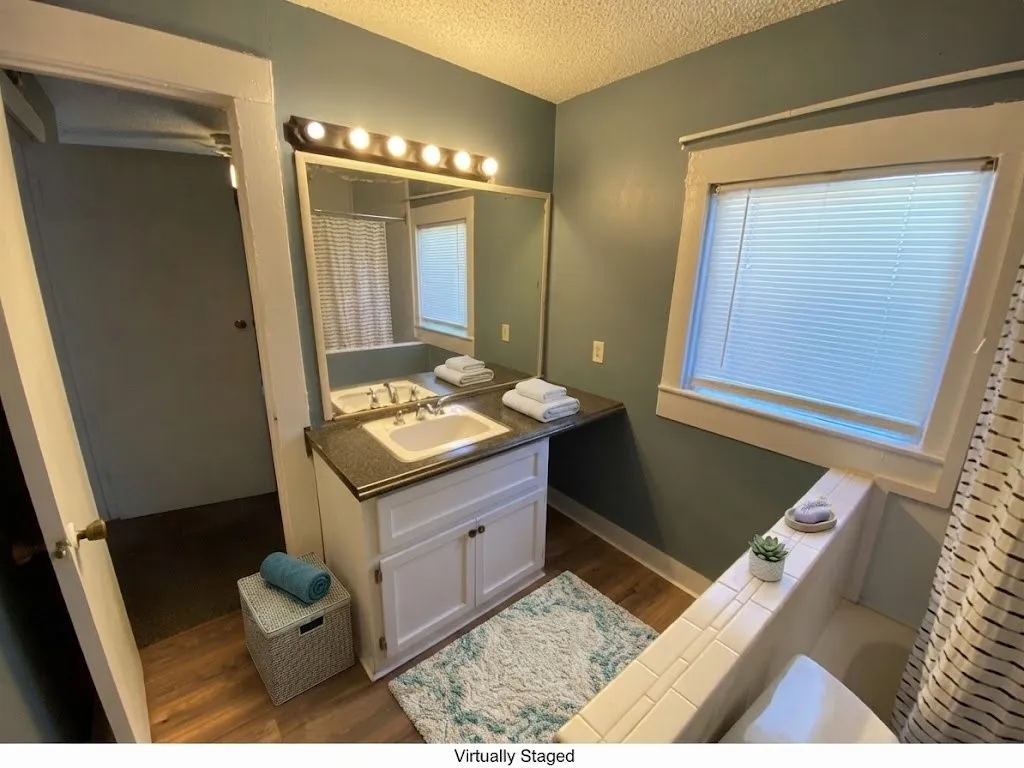 Vanity with integrated sink, dark countertop, and white cabinetry