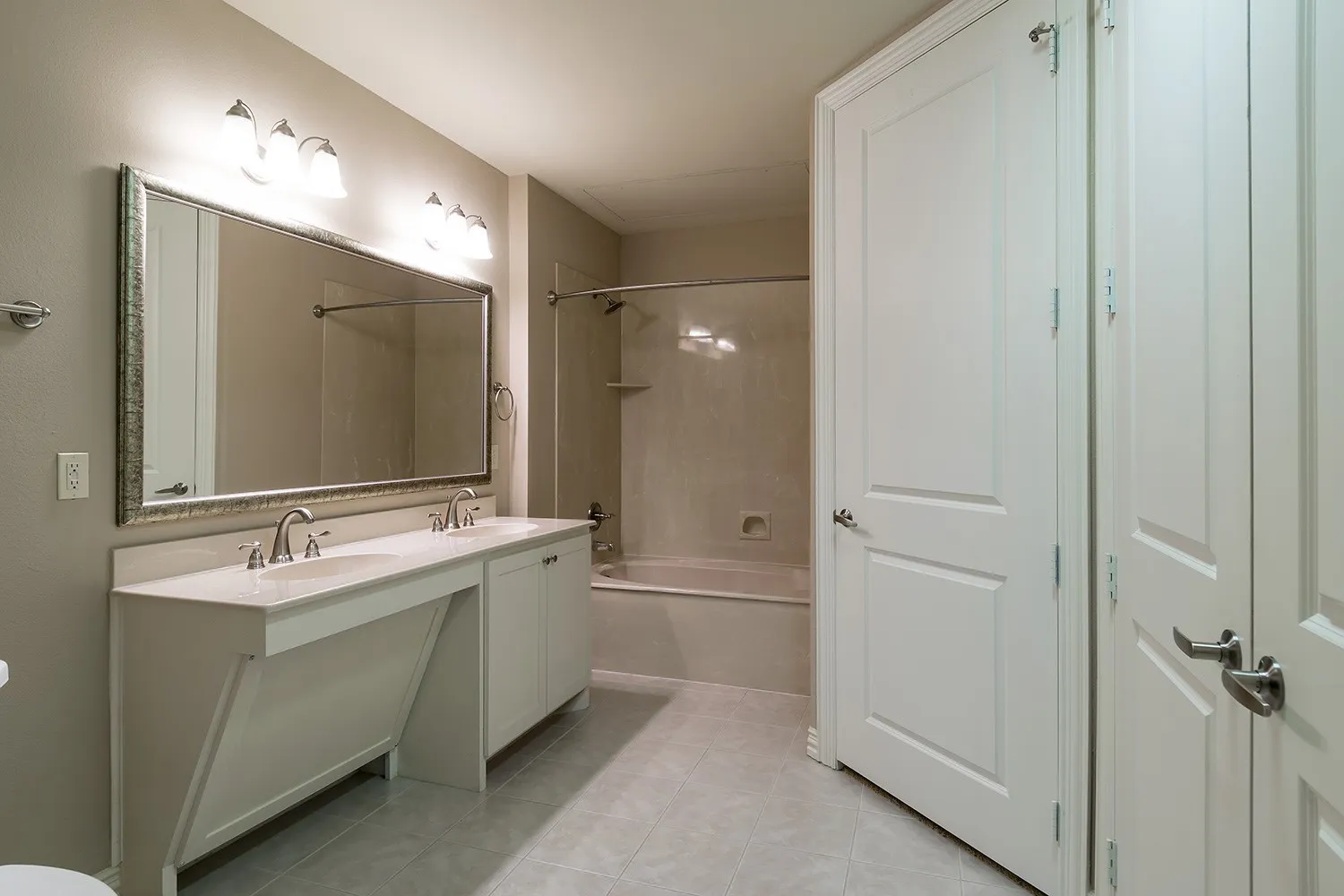 Bathroom with  shower combination, double vanity, and light tile patterned flooring