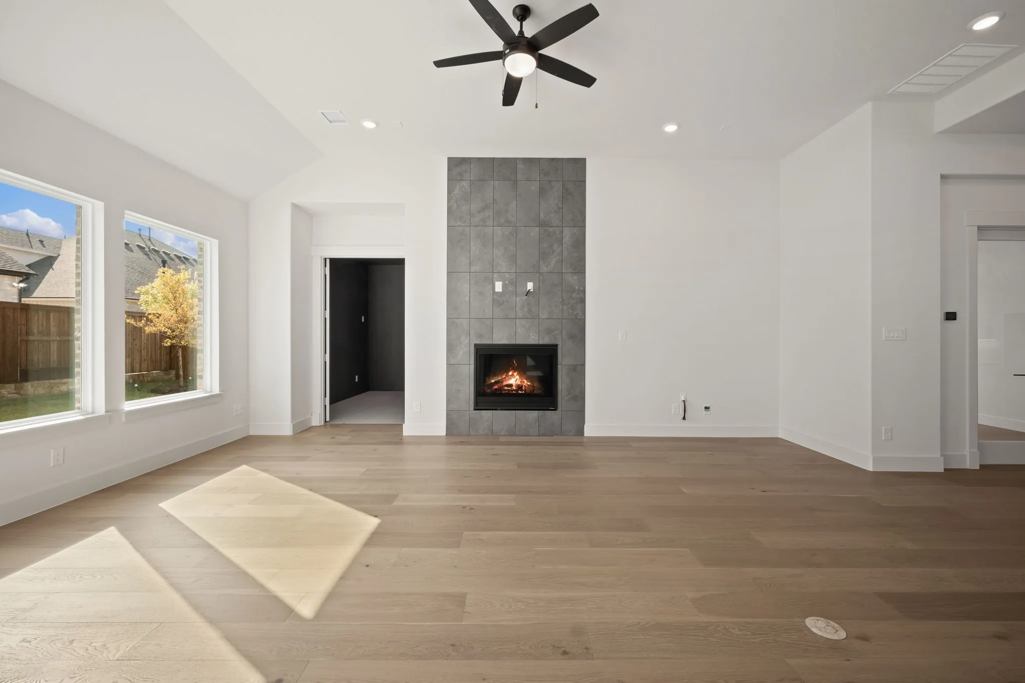 With a striking floor to ceiling fireplace and wall of windows, this spacious family room is the perfect place to host those big game day parties!