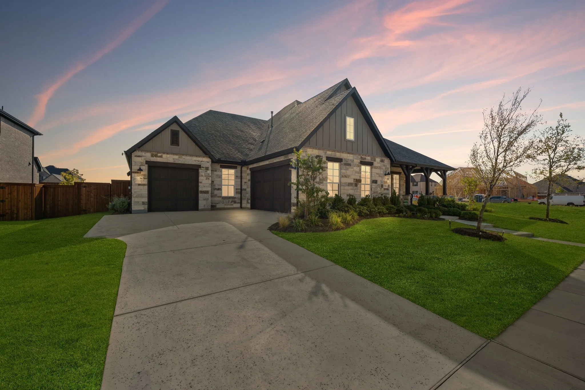 A sophisticated light stone exterior paired with striking dark gables creates stunning curb appeal for this dream home!