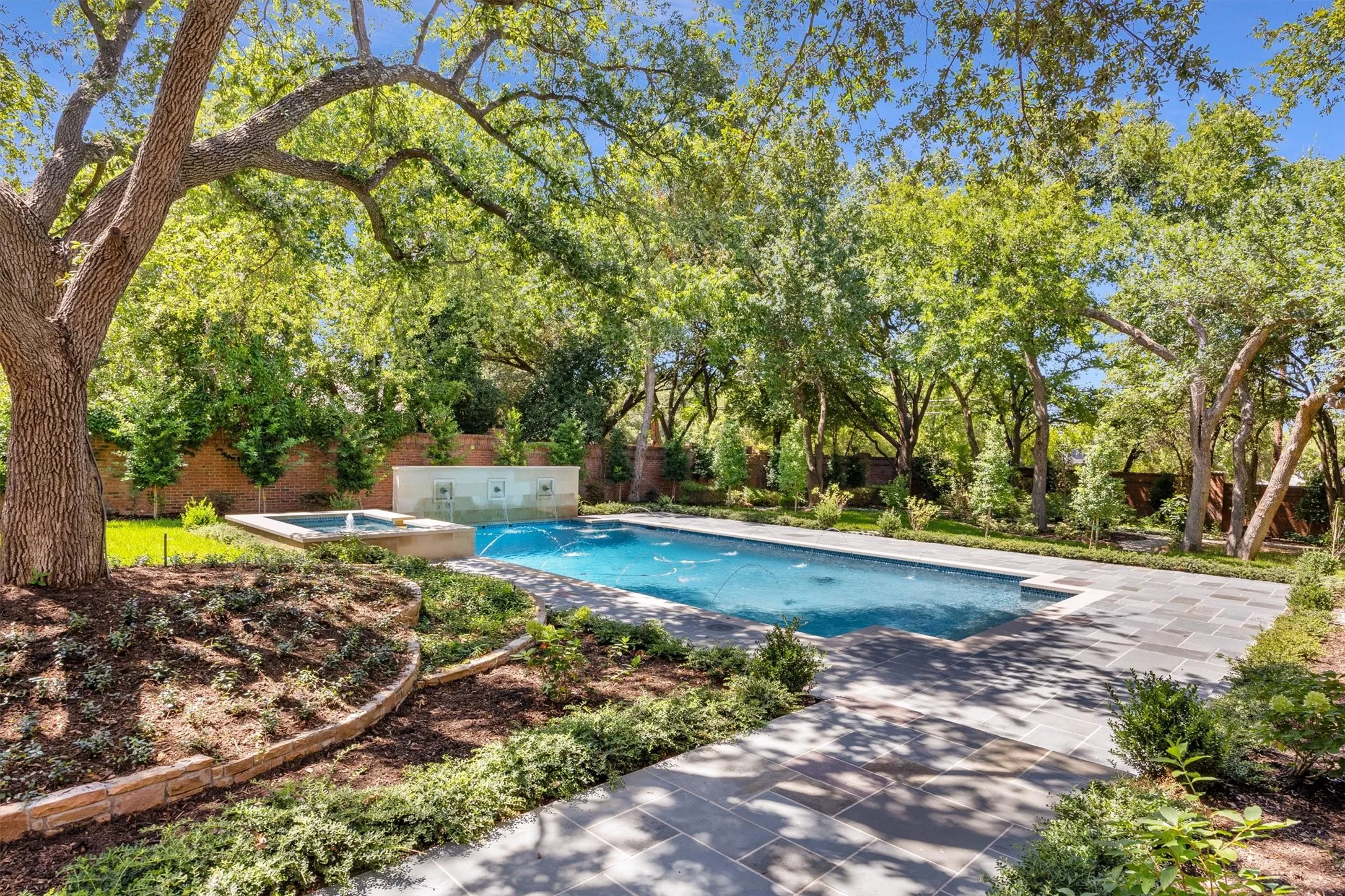 Water wall of fountains to pool and spa with fountain. Tranquility and water features create an ideal setting.