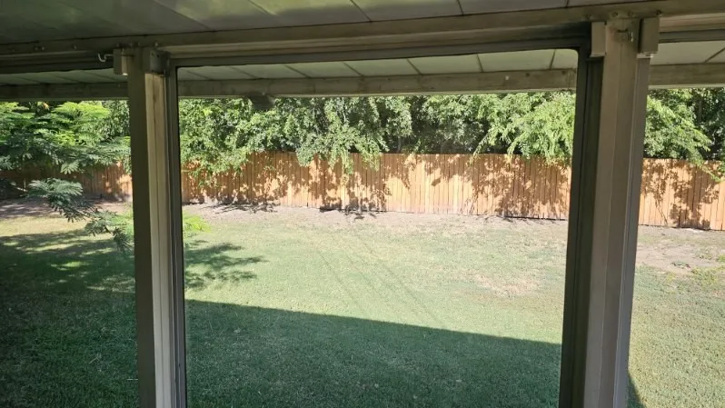 Expansive backyard featuring a new wood fence and mature trees
