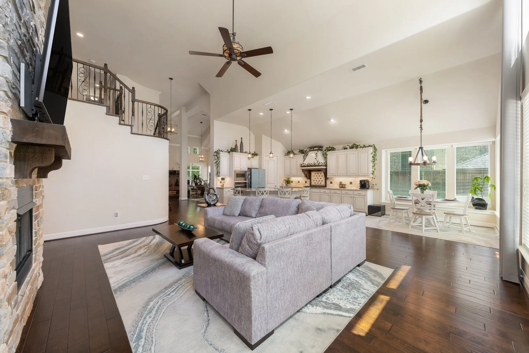 Soaring ceilings, dramatic staircase, beautiful stone fireplace, walls of windows