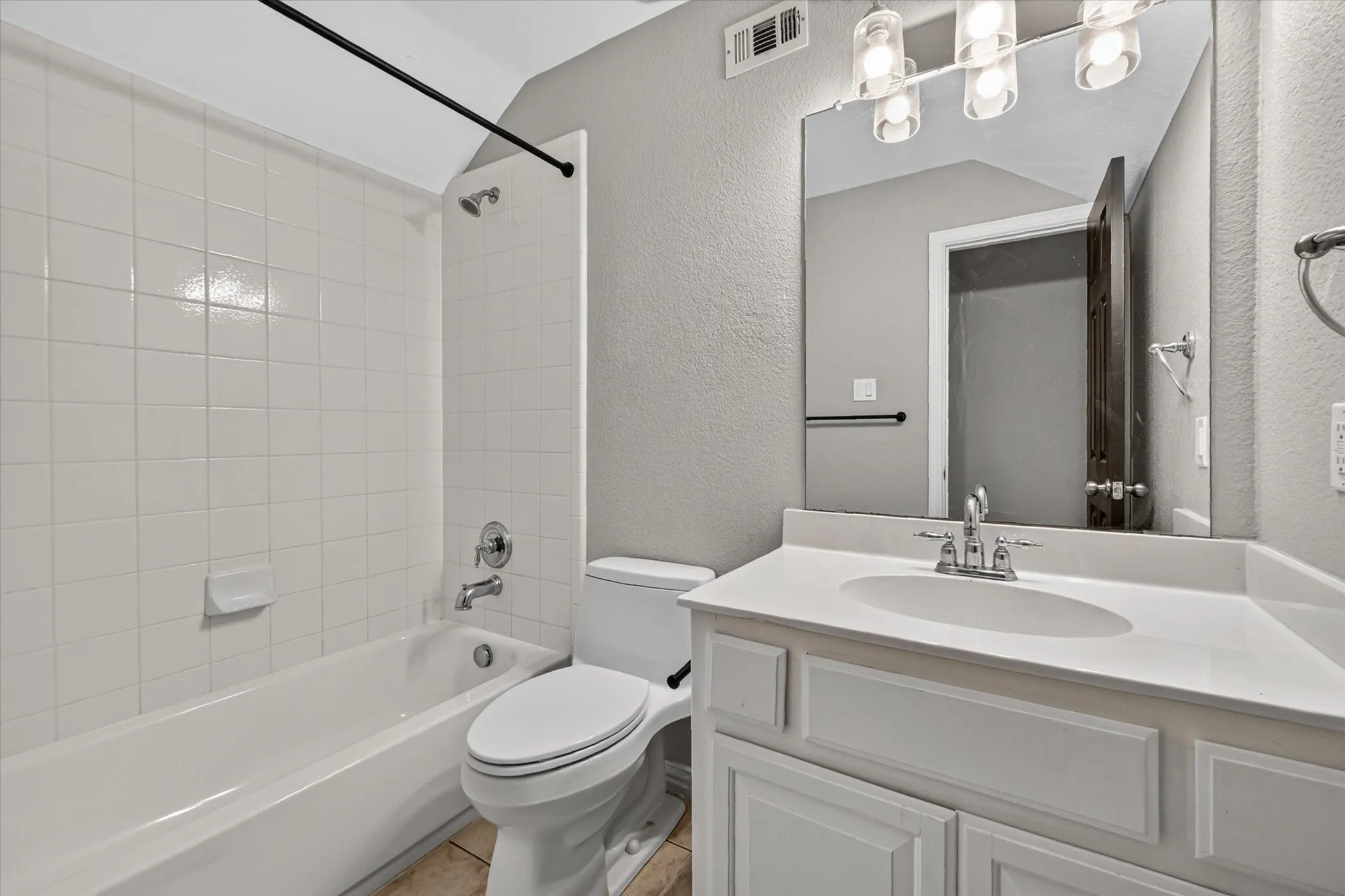 Bathroom featuring a white vanity with an integrated sink, polished chrome faucet, and a wall-mounted mirror