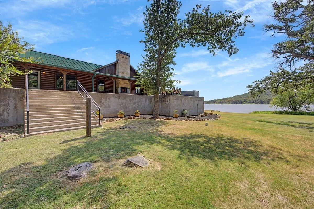 Log cabin exterior with a green metal roof and a stone chimney