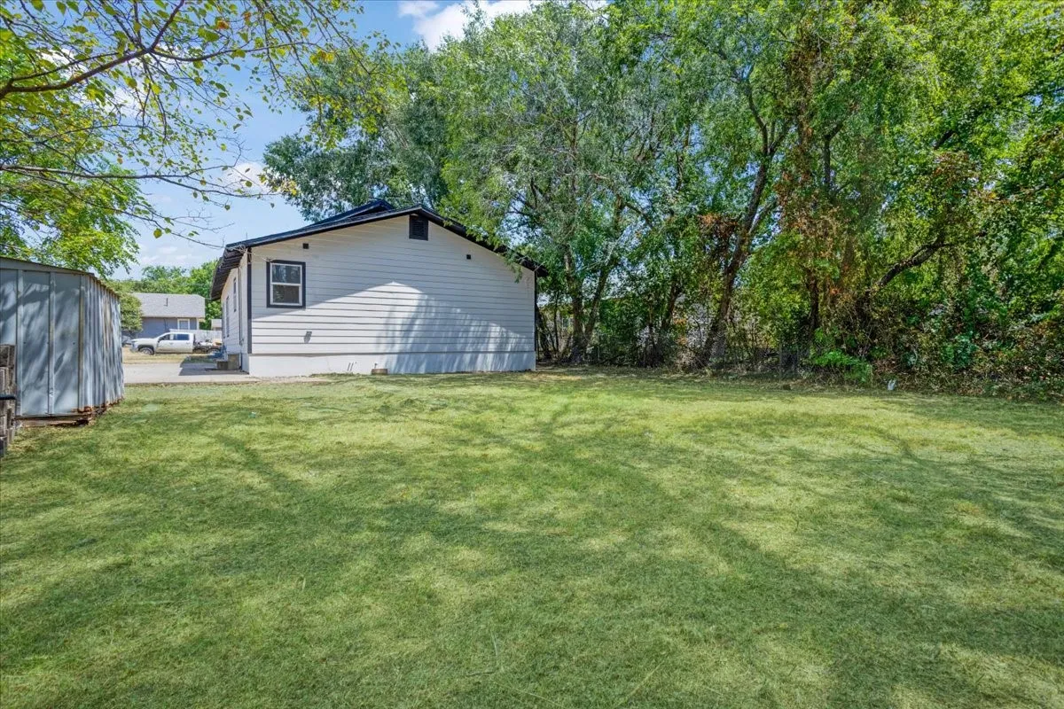 Expansive grassy yard with mature trees