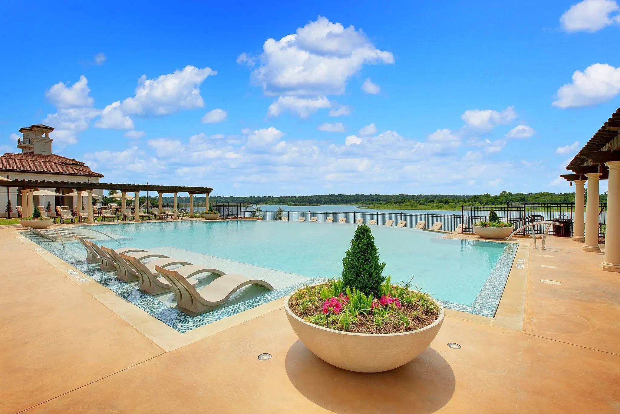 Expansive swimming pool with integrated tanning ledge, surrounded by a paved deck