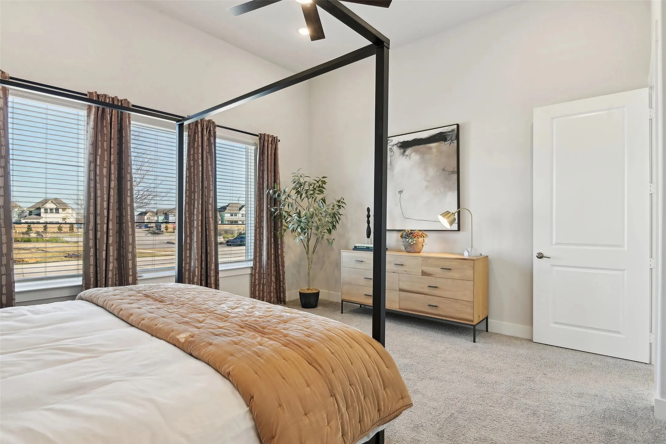 Vaulted ceiling with a ceiling fan, light gray carpeting, and multiple windows with blinds and drapery