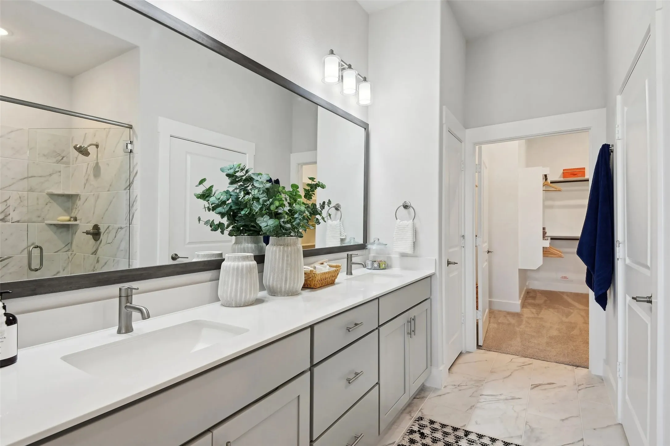Dual sink vanity with light gray cabinetry and brushed nickel fixtures