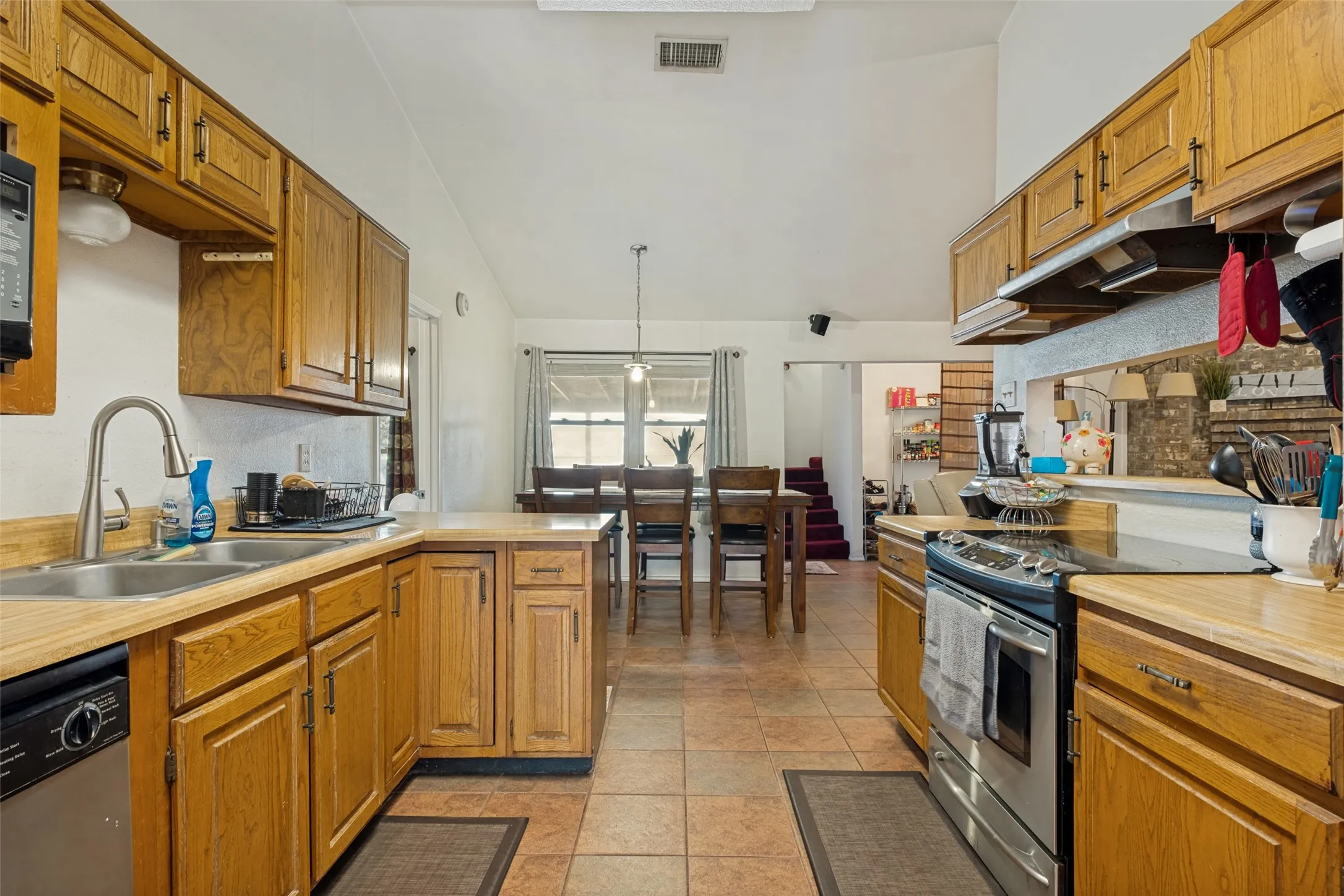 Stainless Appliances in kitchen with natural wood cabinets