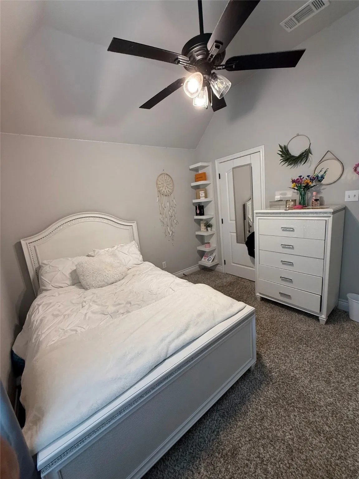 Vaulted ceiling with a dark-tone ceiling fan and lighting fixture