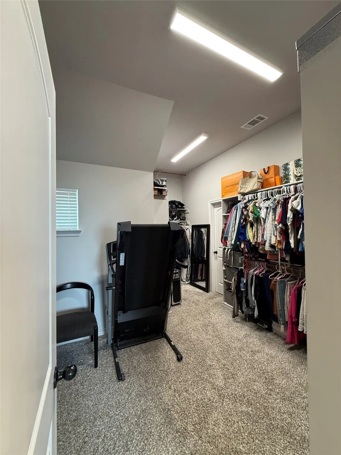 Sloped ceiling, recessed lighting, carpet flooring, built-in shelving, window with blinds