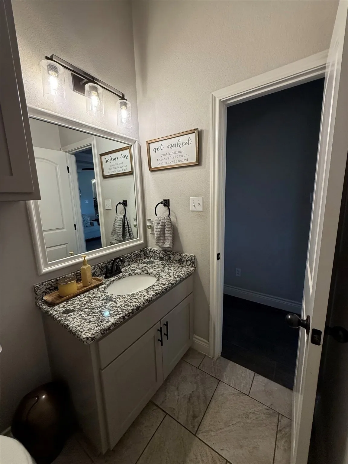 Vanity with a granite countertop, undermount sink, and dark-finish faucet
