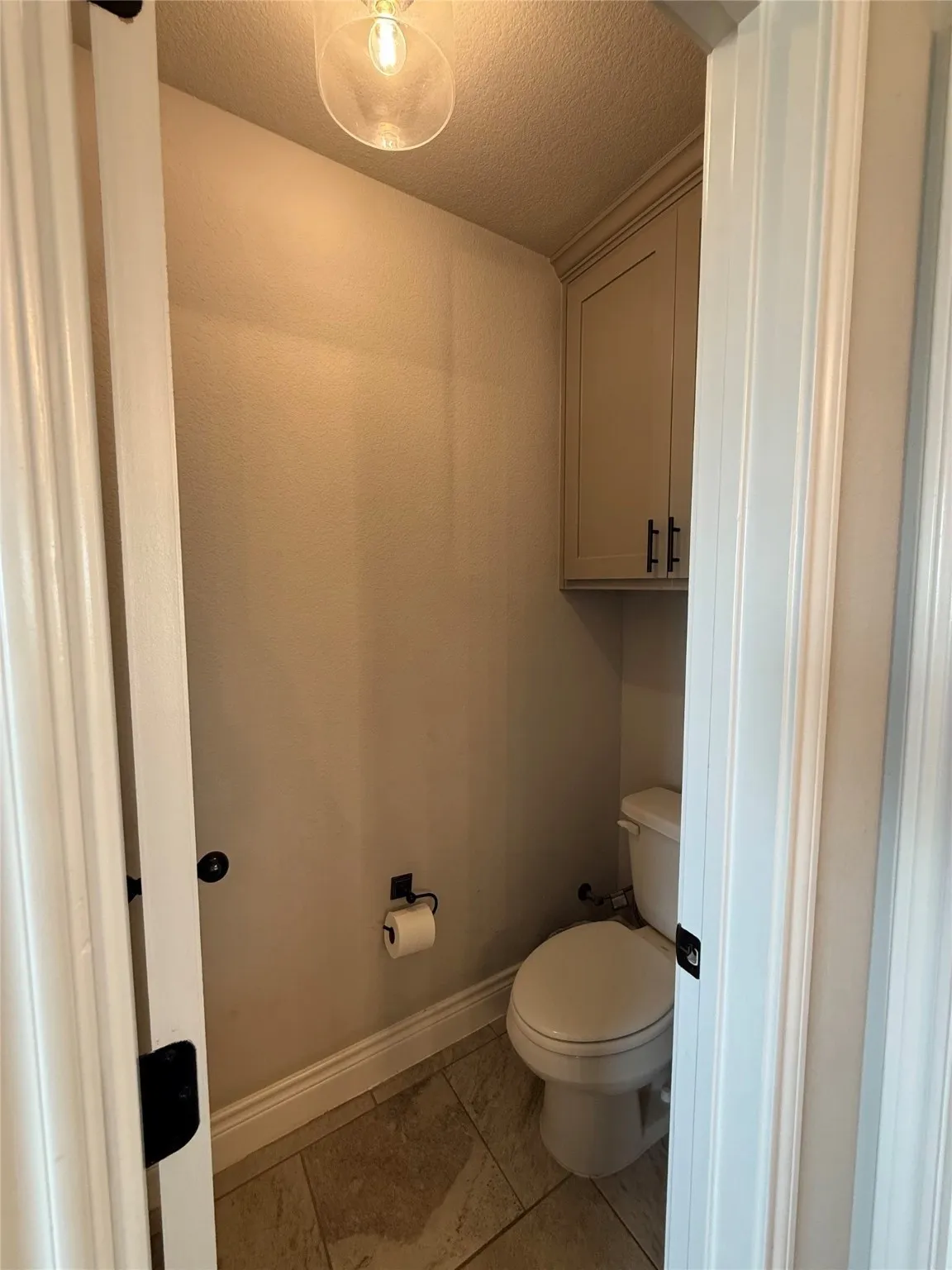 Built-in cabinetry with crown molding, black hardware, and tiled flooring