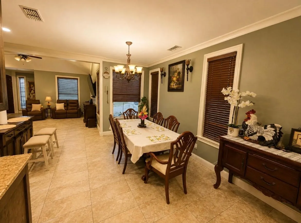 Tile flooring, crown molding, a chandelier, wood blinds, and wall sconces