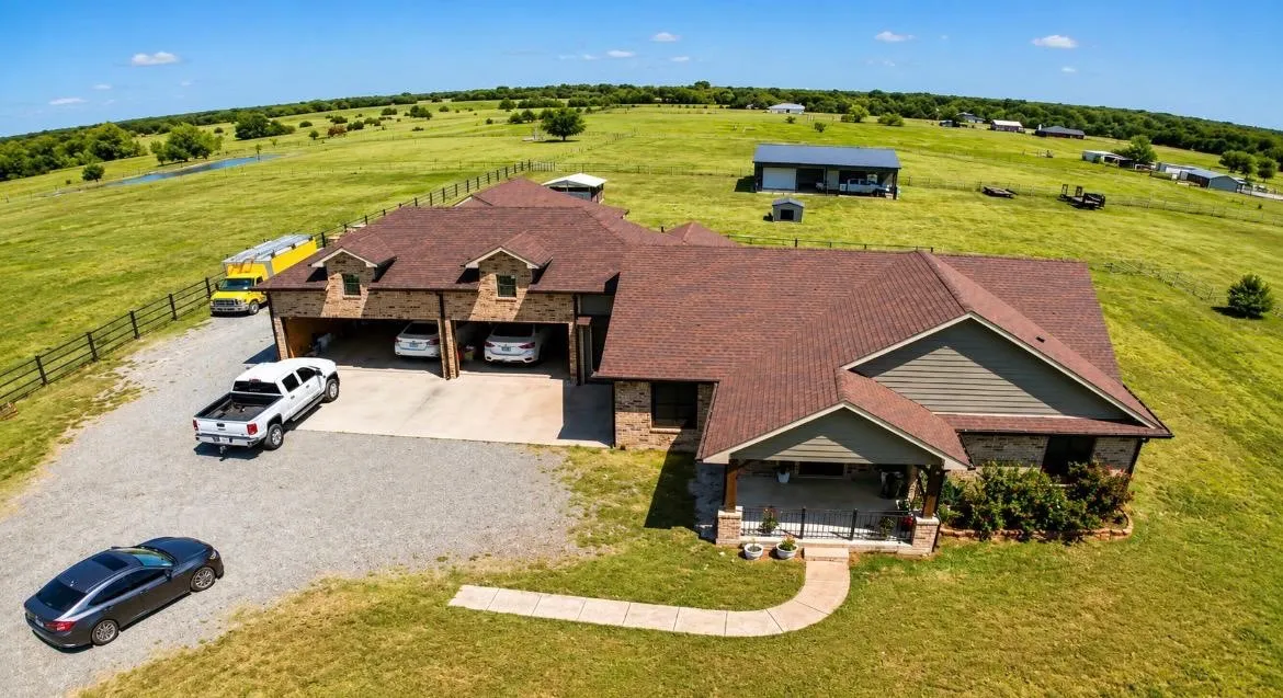 Stone and siding exterior with a covered front porch featuring stone columns and black railings