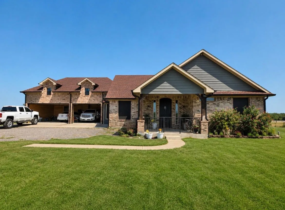Brick exterior with shingle roofing, front entry porch, and attached multi-car covered parking
