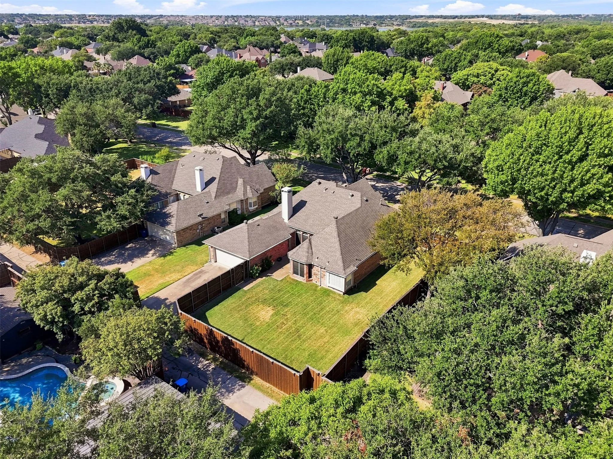 Expansive residential property featuring a large landscaped backyard, mature trees, and privacy fencing
