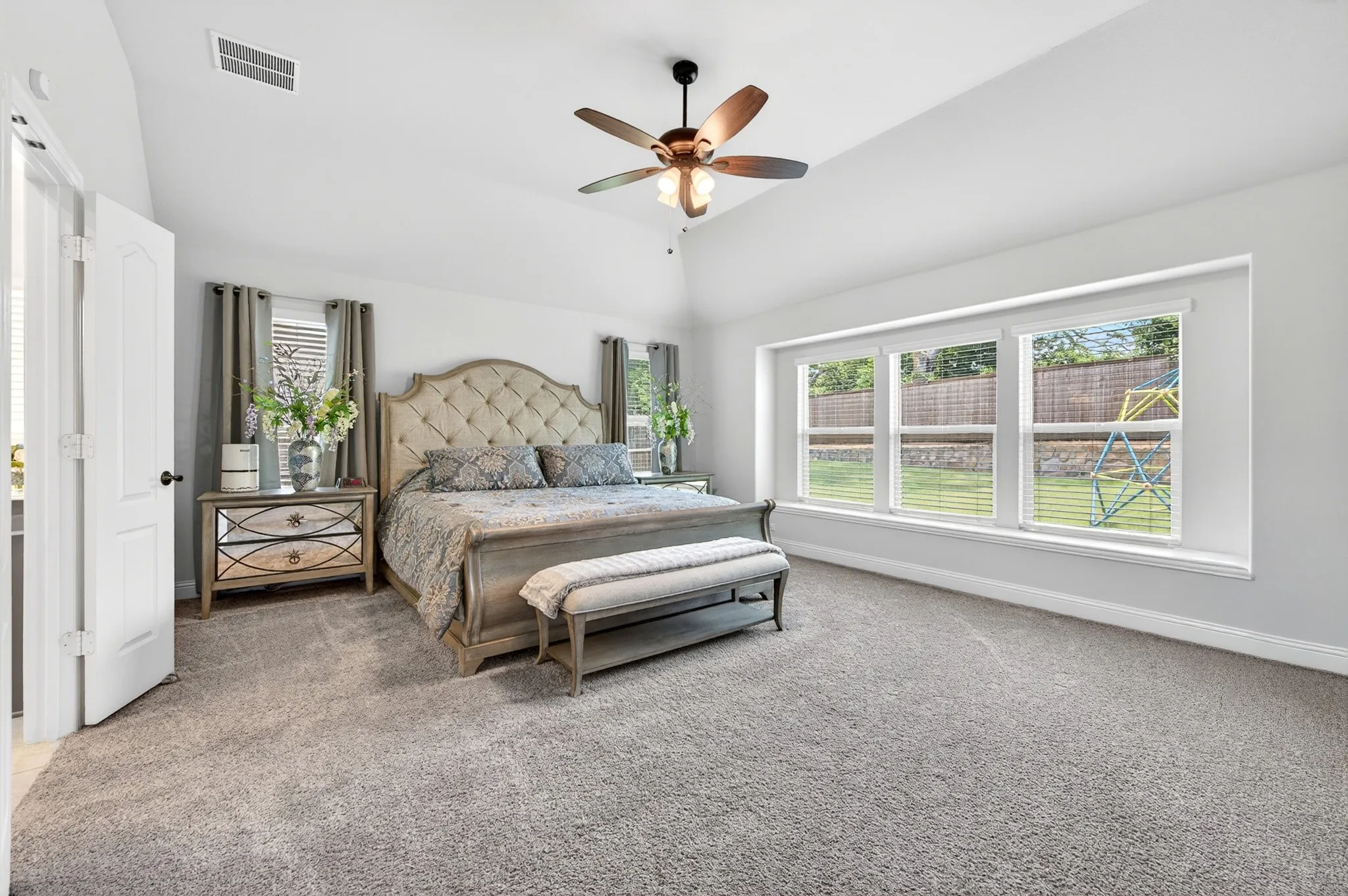 Primary Bedroom has space for king-sized bed plus oversized night stands and sitting area and view of backyard.