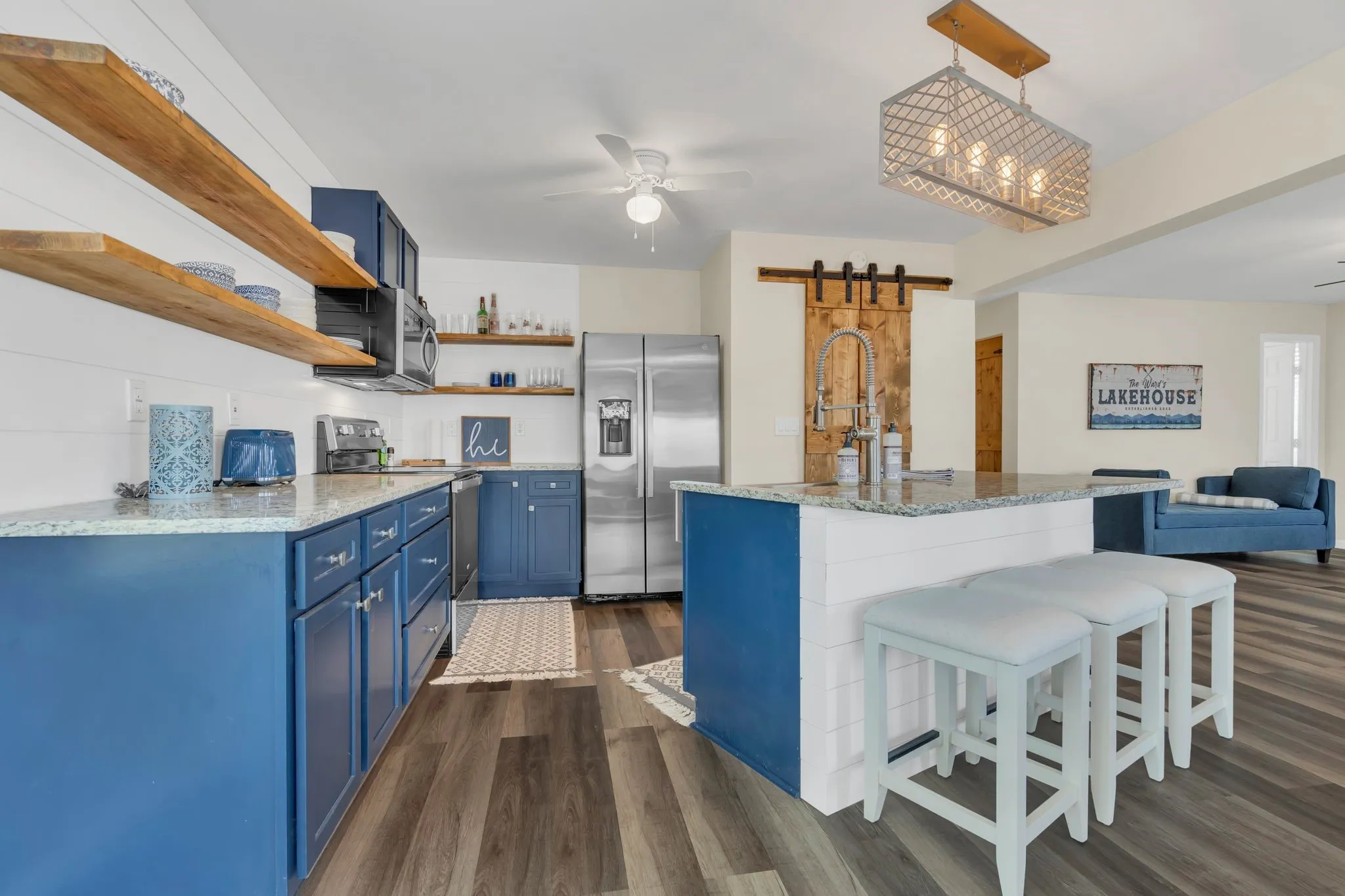 Kitchen featuring blue cabinetry, light-toned countertops, and wood-finish flooring