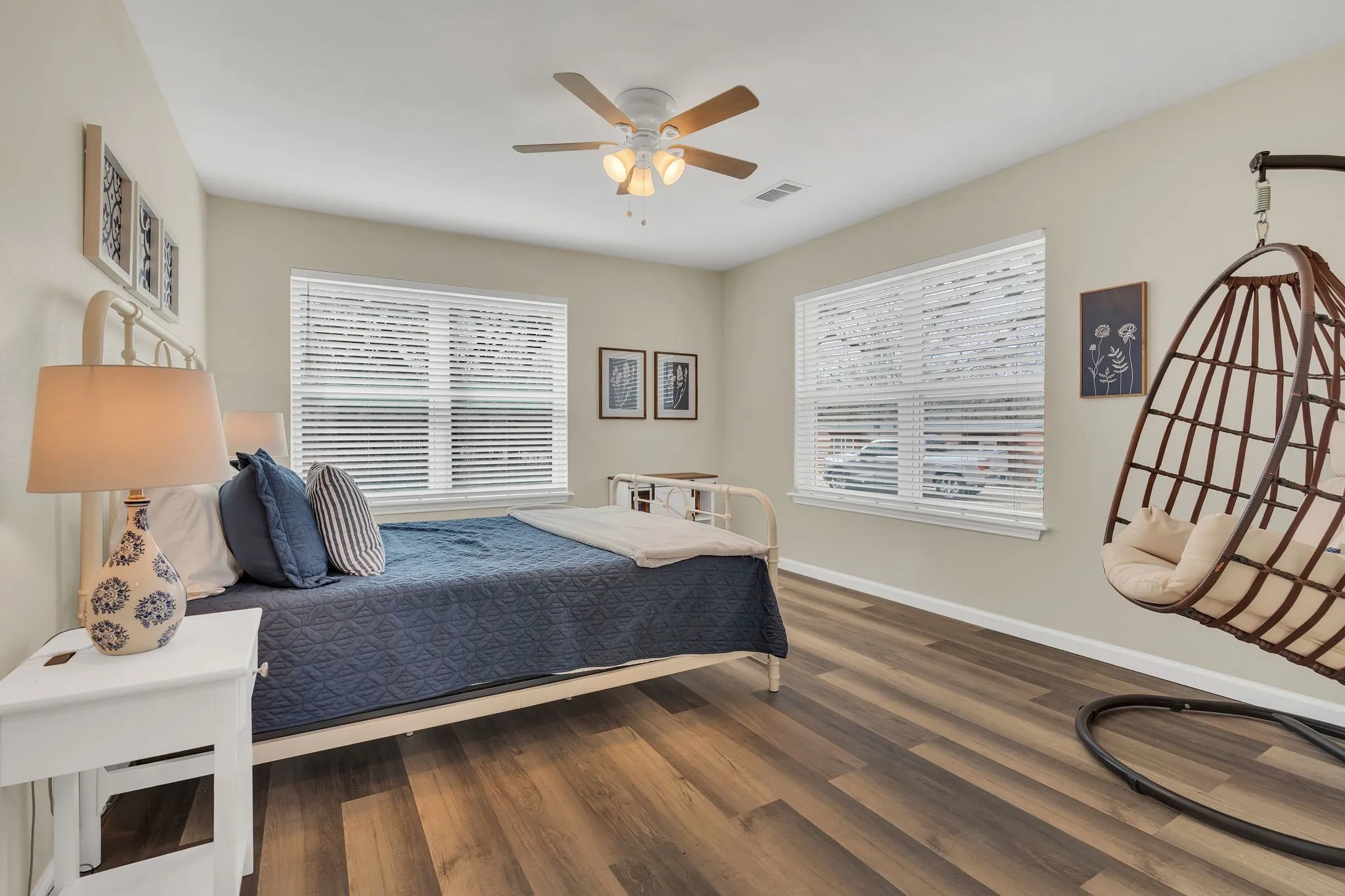 Recessed lighting, wood-finish flooring, two windows with blinds, and a ceiling fan with integrated lighting