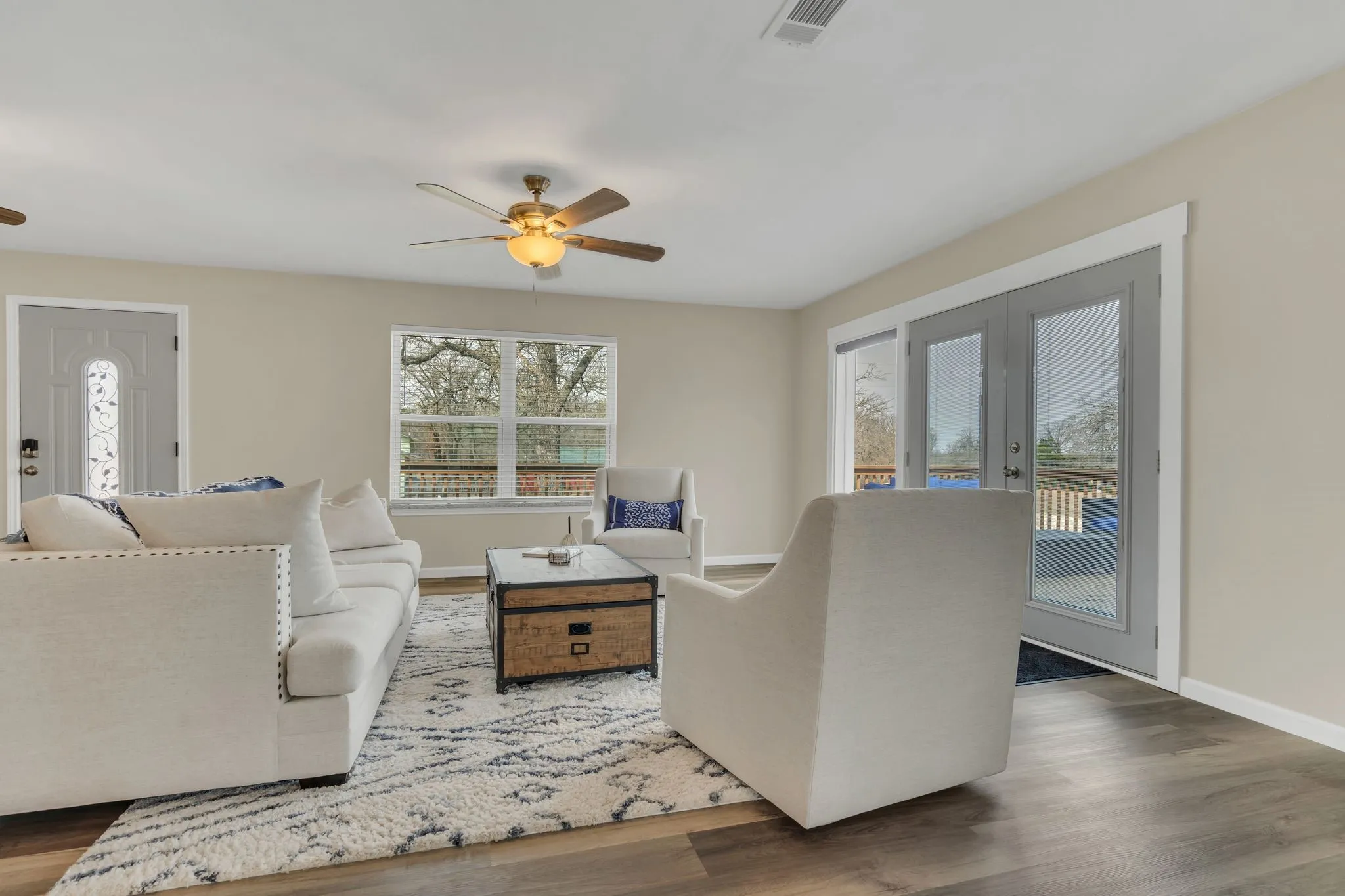 Recessed lighting, wood-finish flooring, ceiling fan, double glass-paneled doors, and a window providing natural illumination