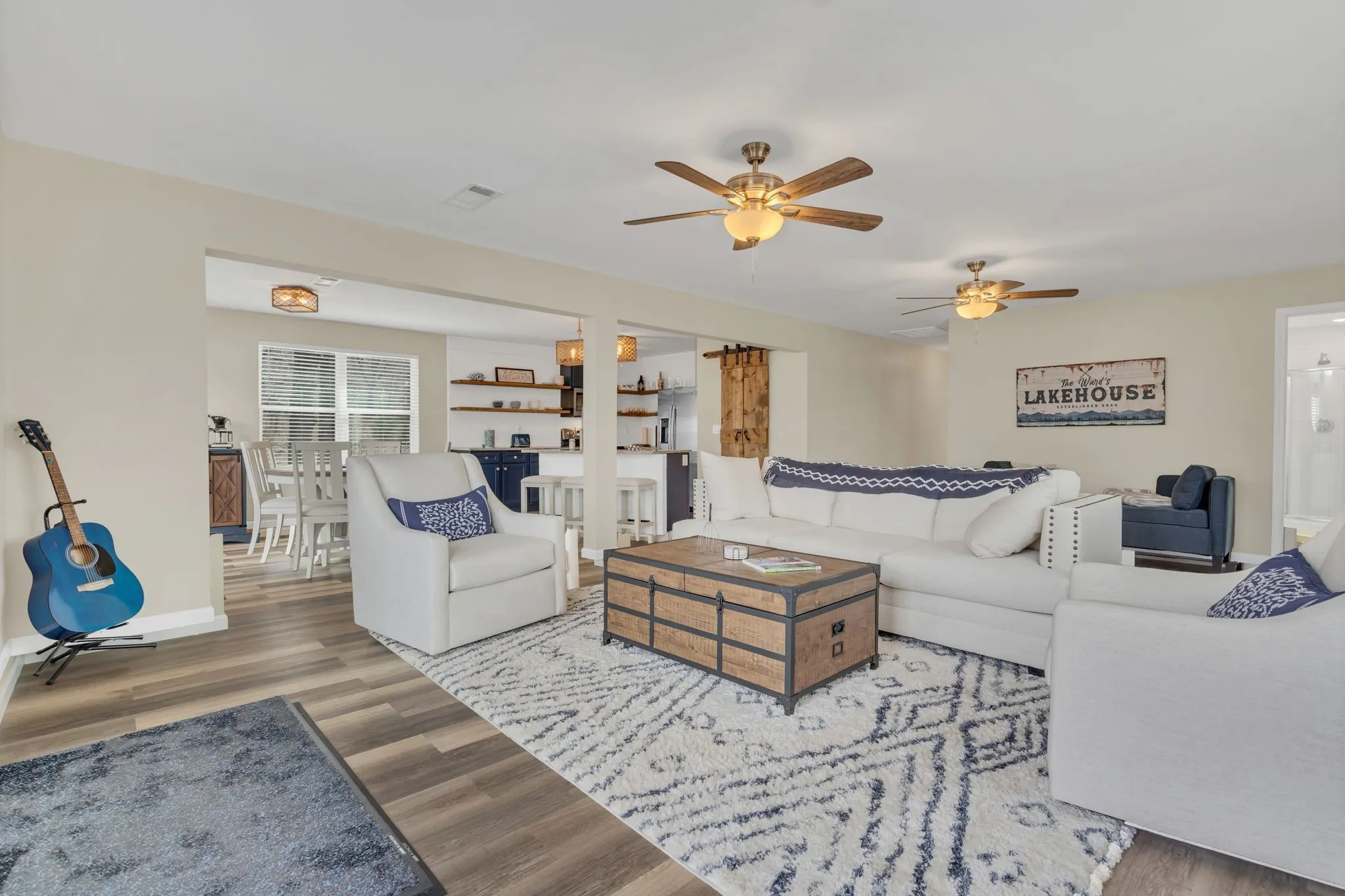 Open-concept living space with wood-finish flooring, two ceiling fans, and recessed lighting