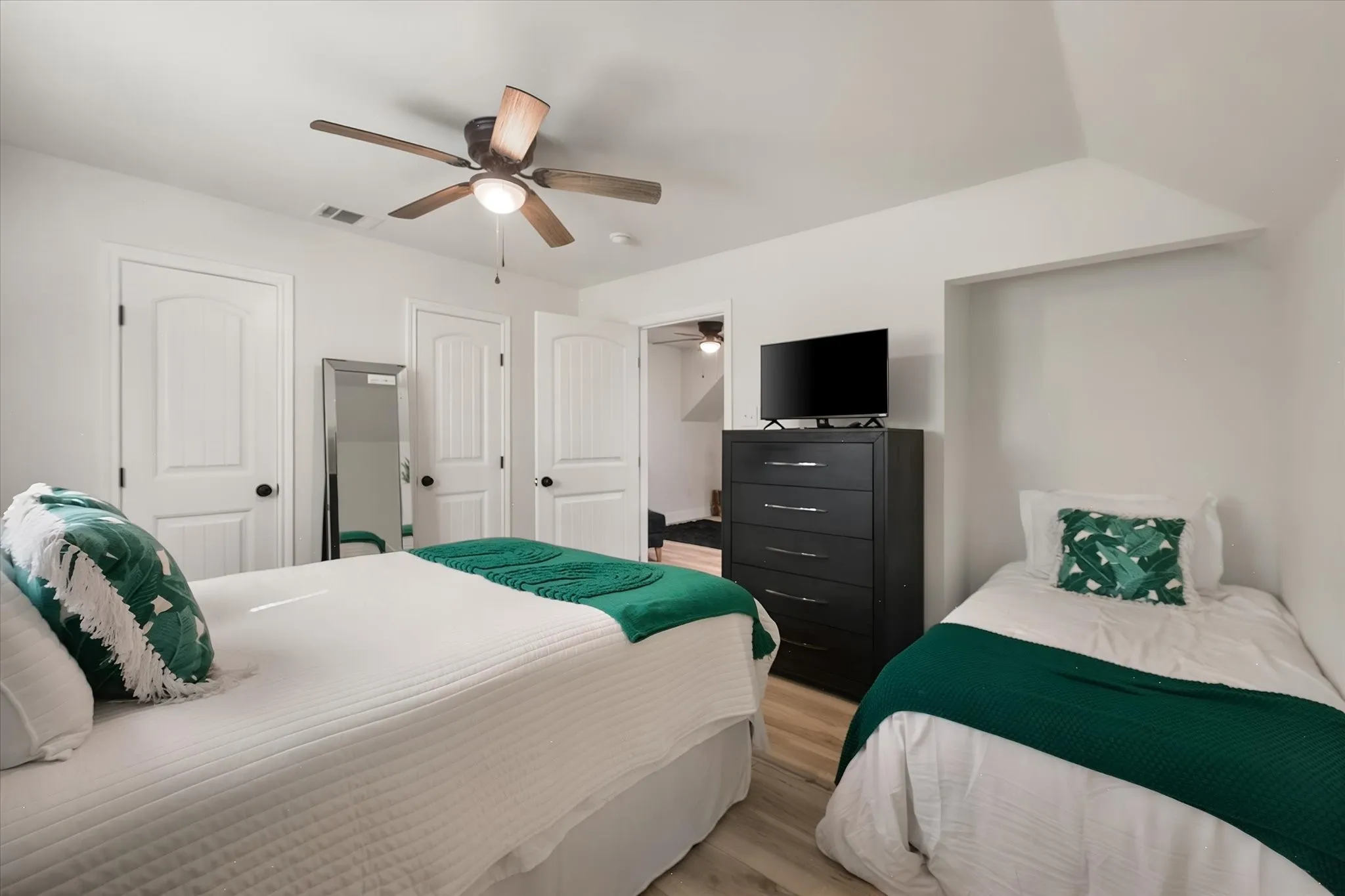 Generously sized upstairs bedroom accommodates multiple beds, making it an excellent option for family and guests at this waterfront retreat.