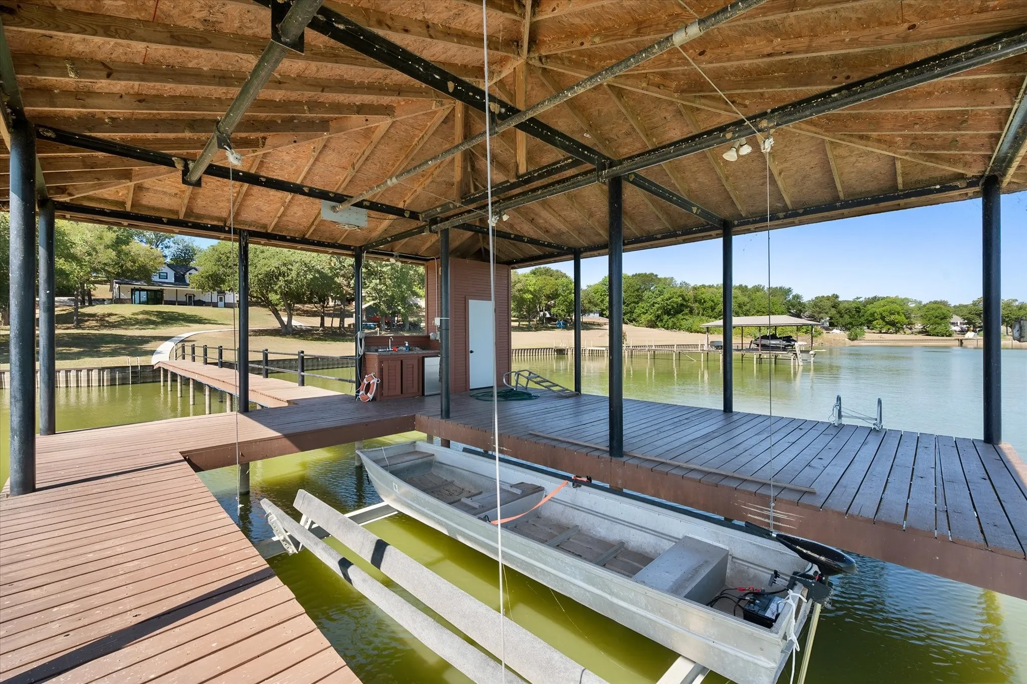 Covered private boathouse combines a boat lift with generous deck space for convenient recreation directly on Richland Chambers Lake.