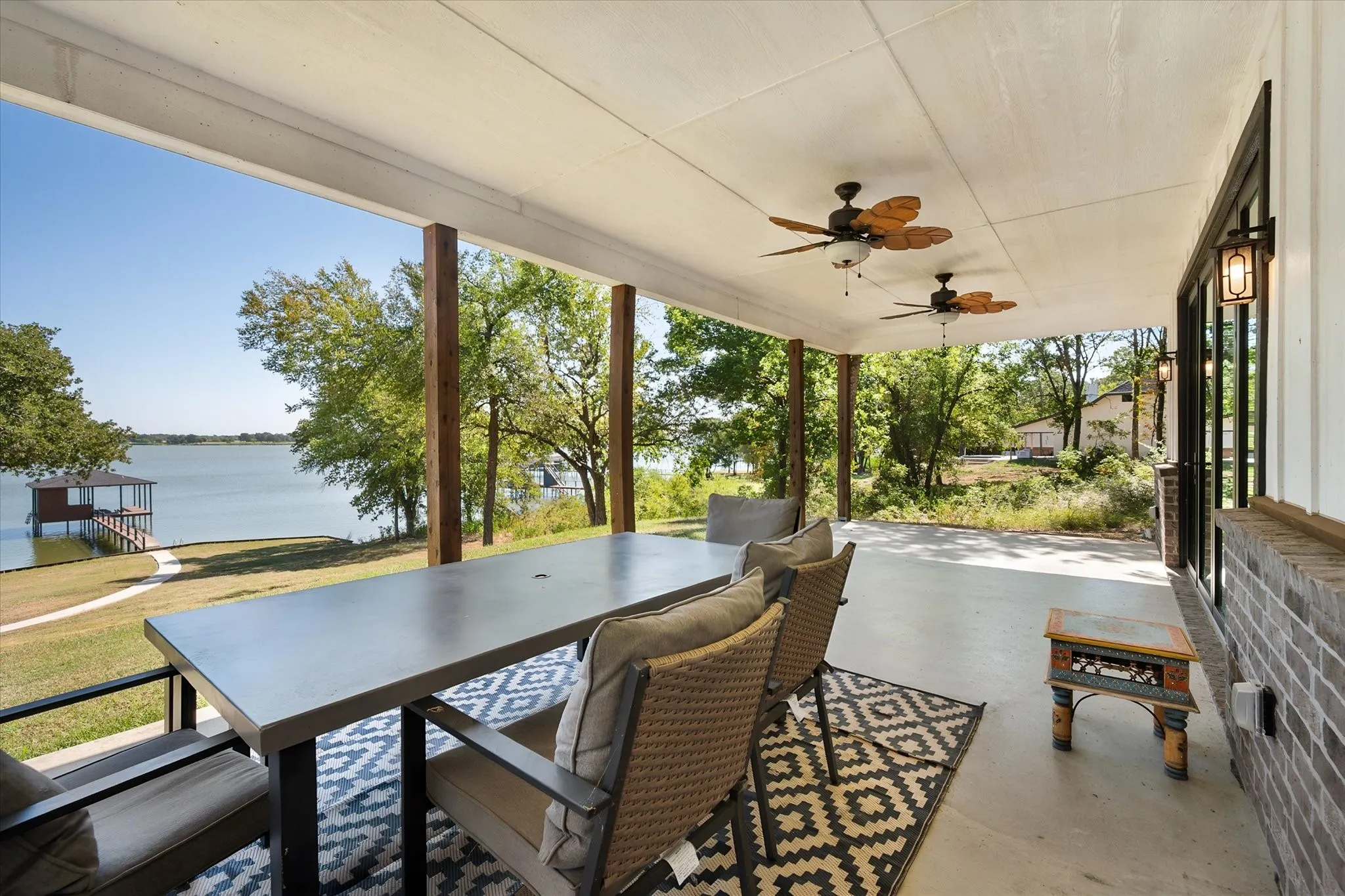 Covered waterfront patio creates an inviting outdoor dining area with mature shade trees and beautiful views toward Richland Chambers Lake.