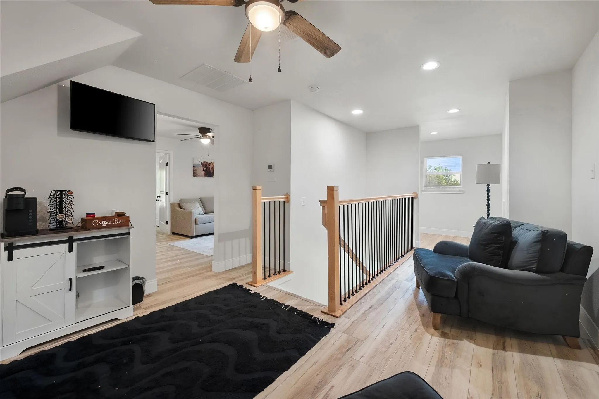 Second-floor living area overlooks the staircase and provides additional flexible space for games, conversation, or a casual family retreat.