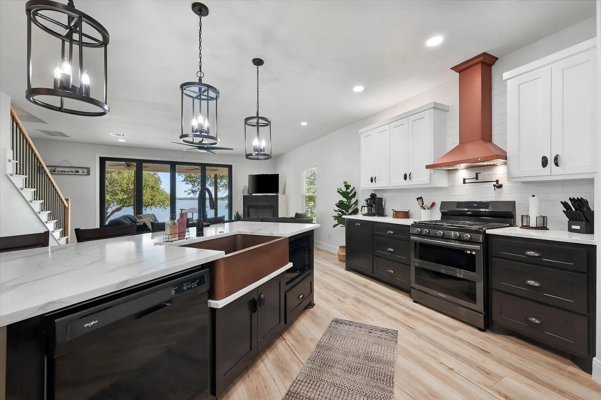 Spacious chef-inspired kitchen combines a large center island, generous storage, modern appliances, and sophisticated black-and-white cabinetry.