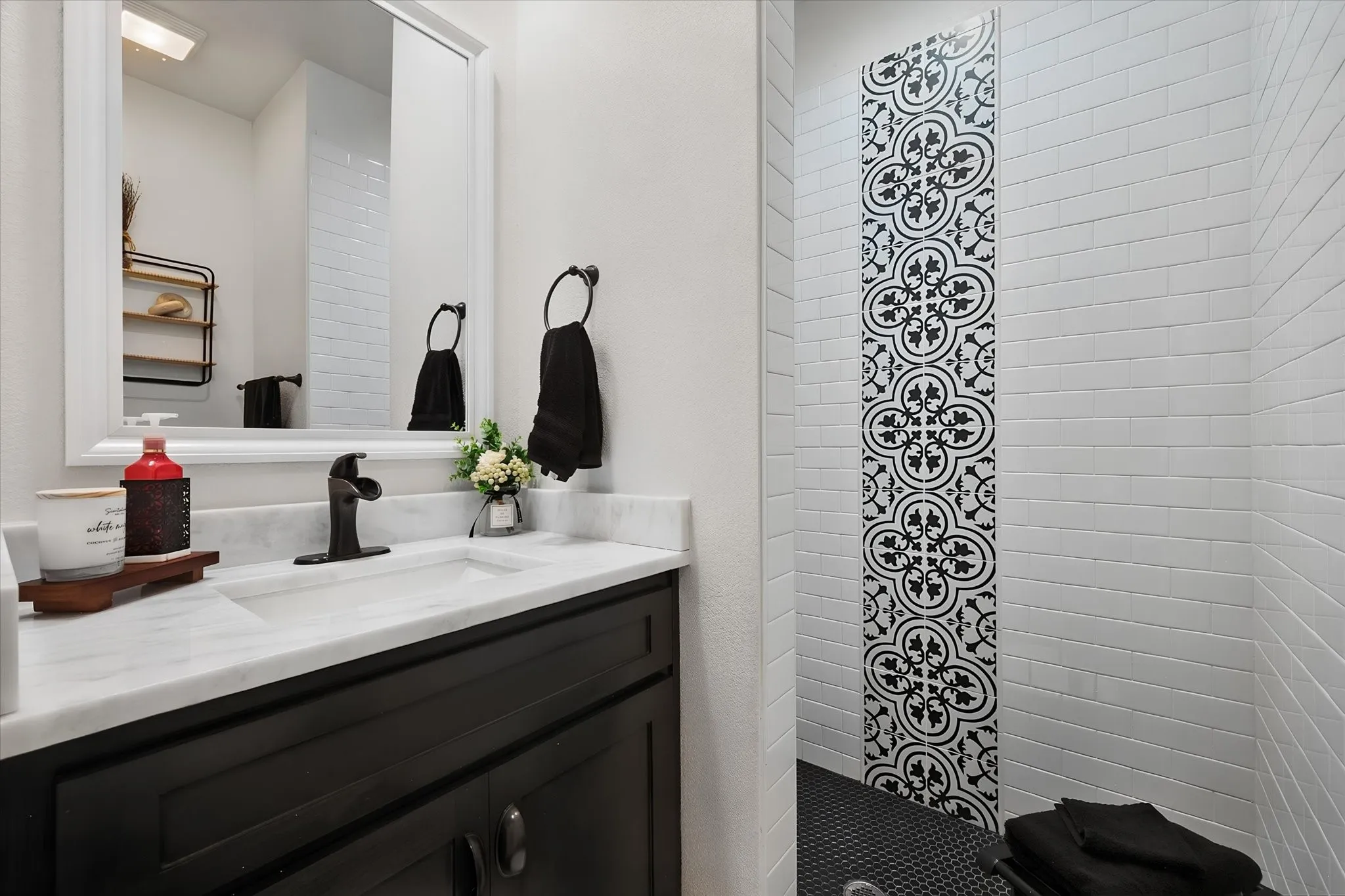 Eye-catching bathroom features a modern vanity and walk-in shower accented by distinctive decorative tile for a custom designer look.