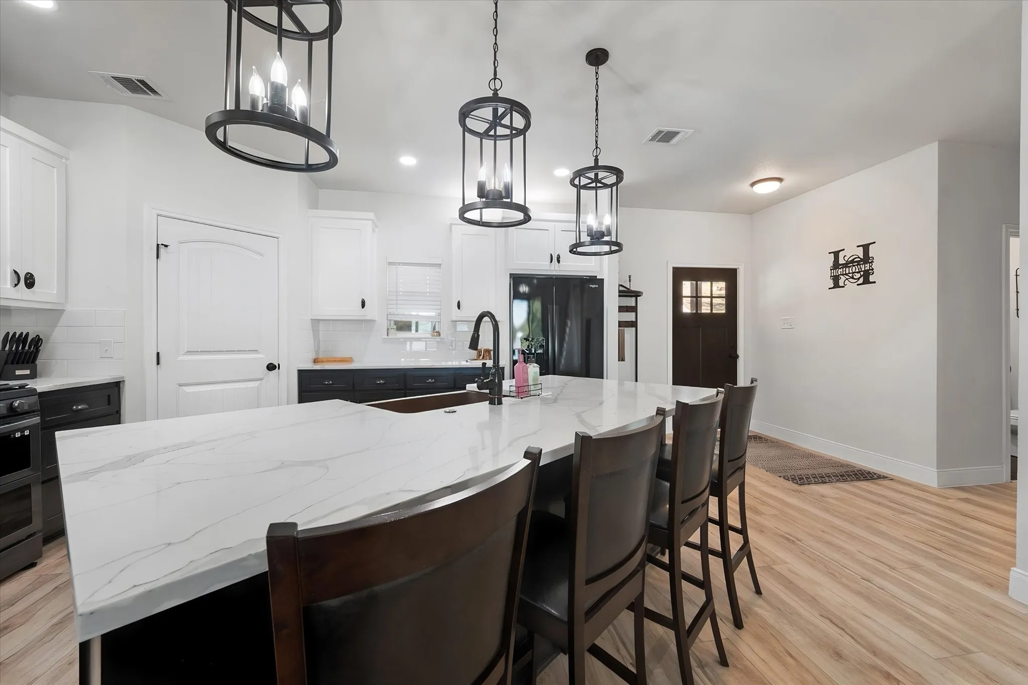 Modern farmhouse kitchen offers abundant cabinetry, expansive countertop space, island seating, and an open layout ideal for entertaining.
