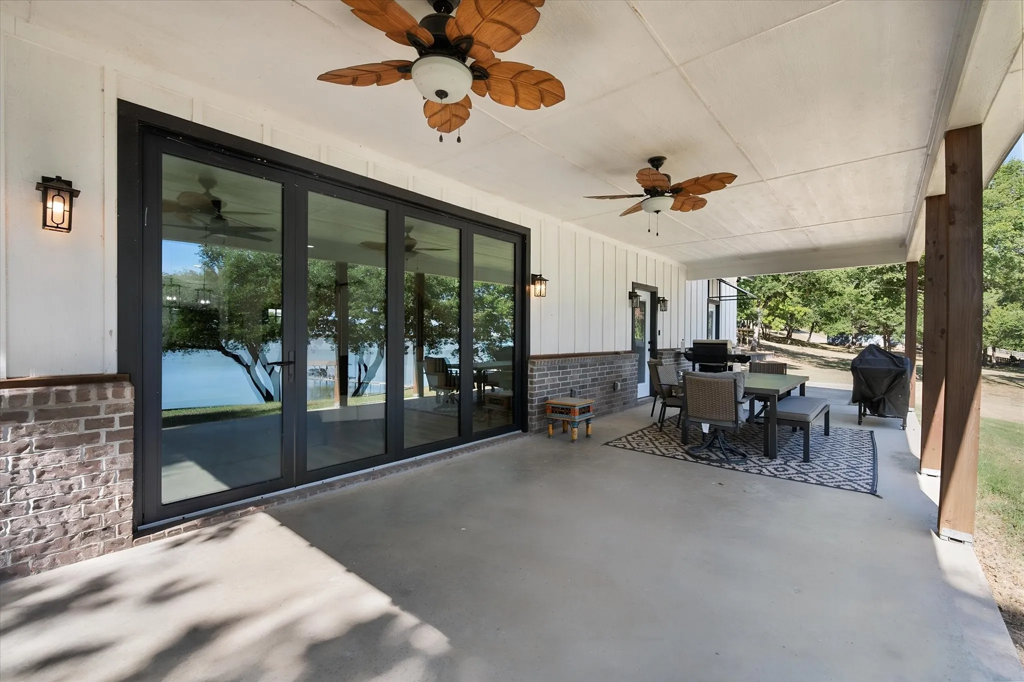 Oversized covered back porch and expansive glass doors create seamless indoor-outdoor living at this Corsicana, Texas lake house.