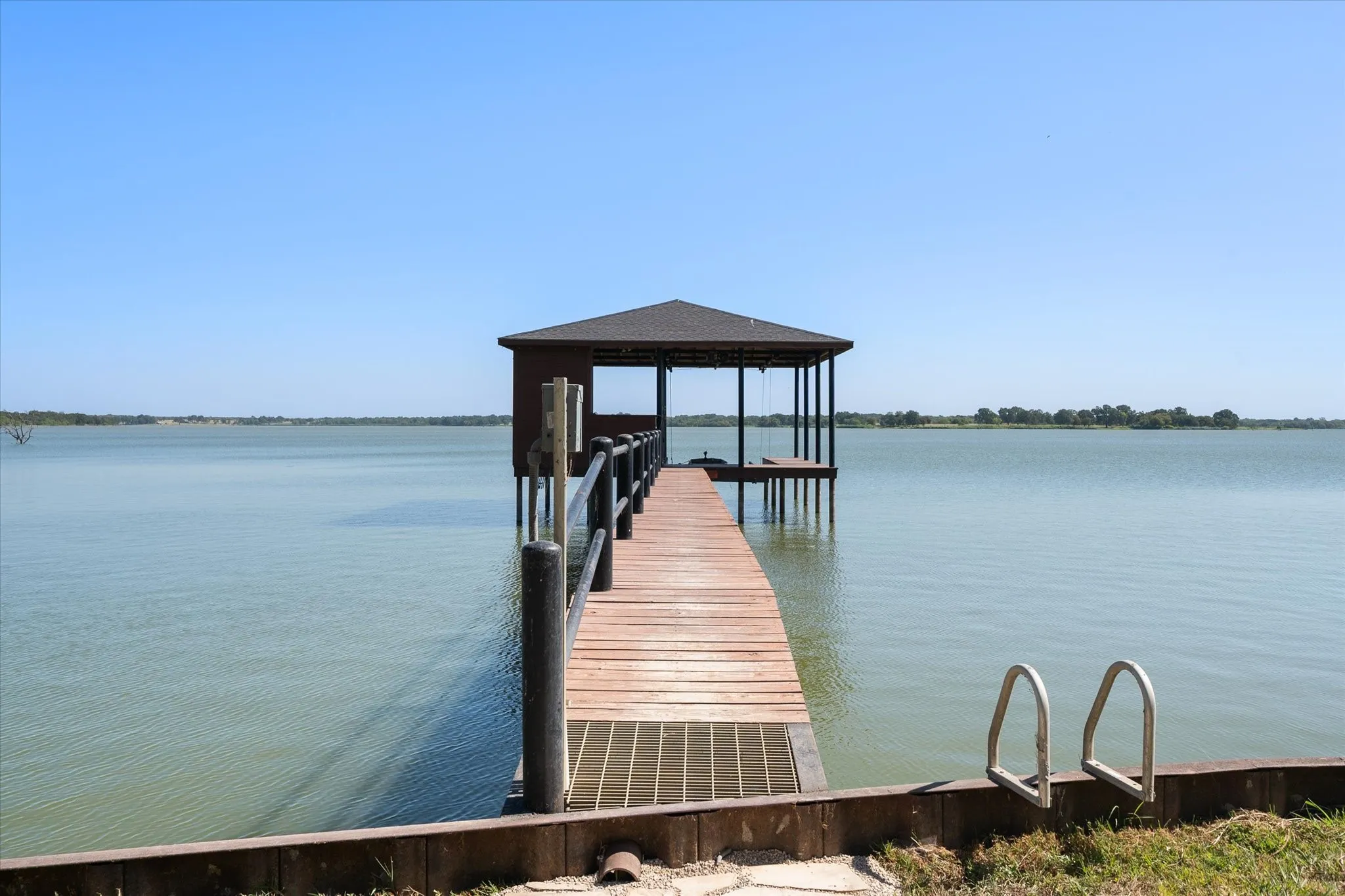 Private covered boathouse and walkway extend directly into the open waters of Richland Chambers Lake for effortless lakefront recreation.