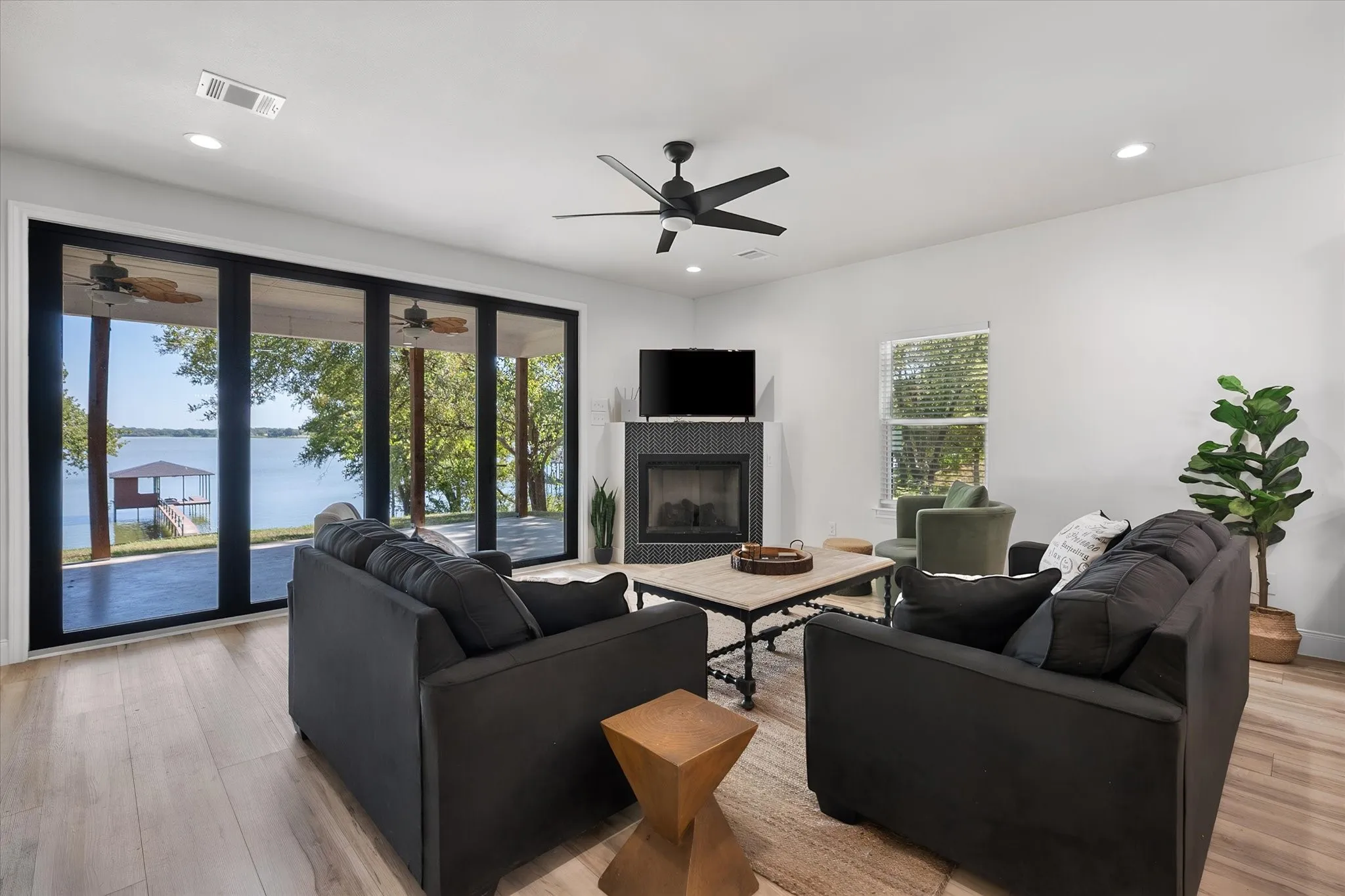 Bright open-concept living room features expansive glass doors framing picturesque Richland Chambers Lake views and easy access to the covered patio.