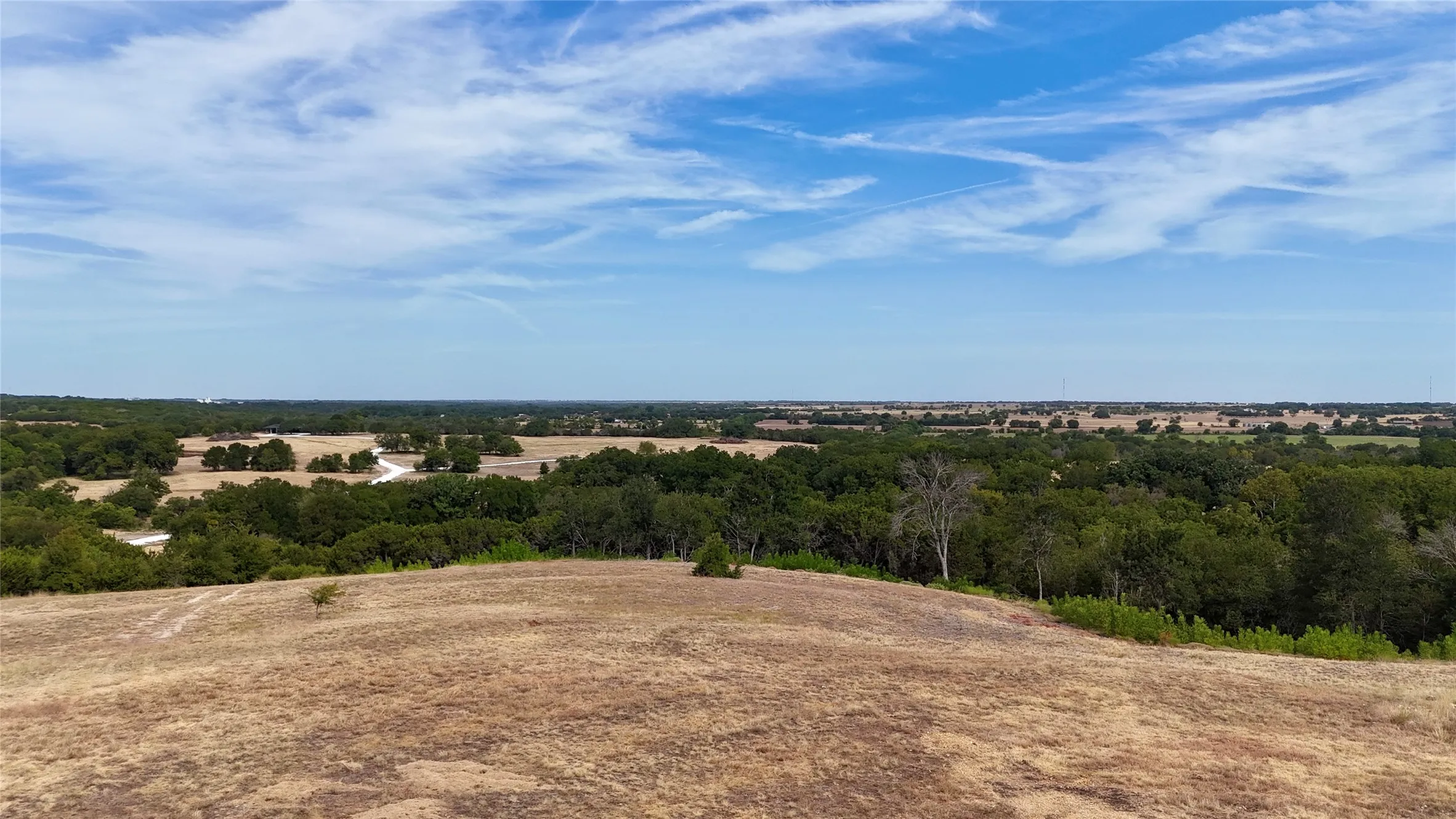 Expansive open land featuring mature trees and a vast natural landscape