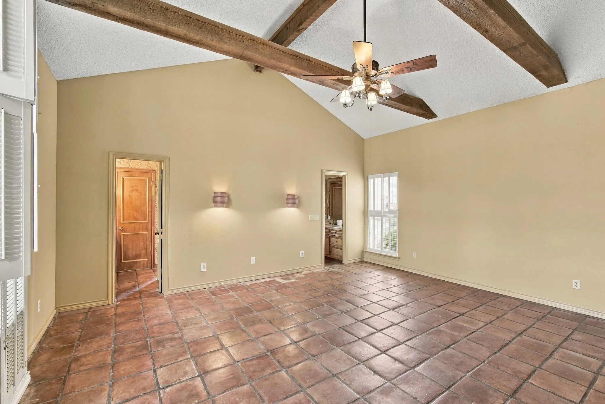 Primary Bedroom with vaulted ceiling and beams, dual vanity en suite bath with walk in closets, private office and hidden safe room.
