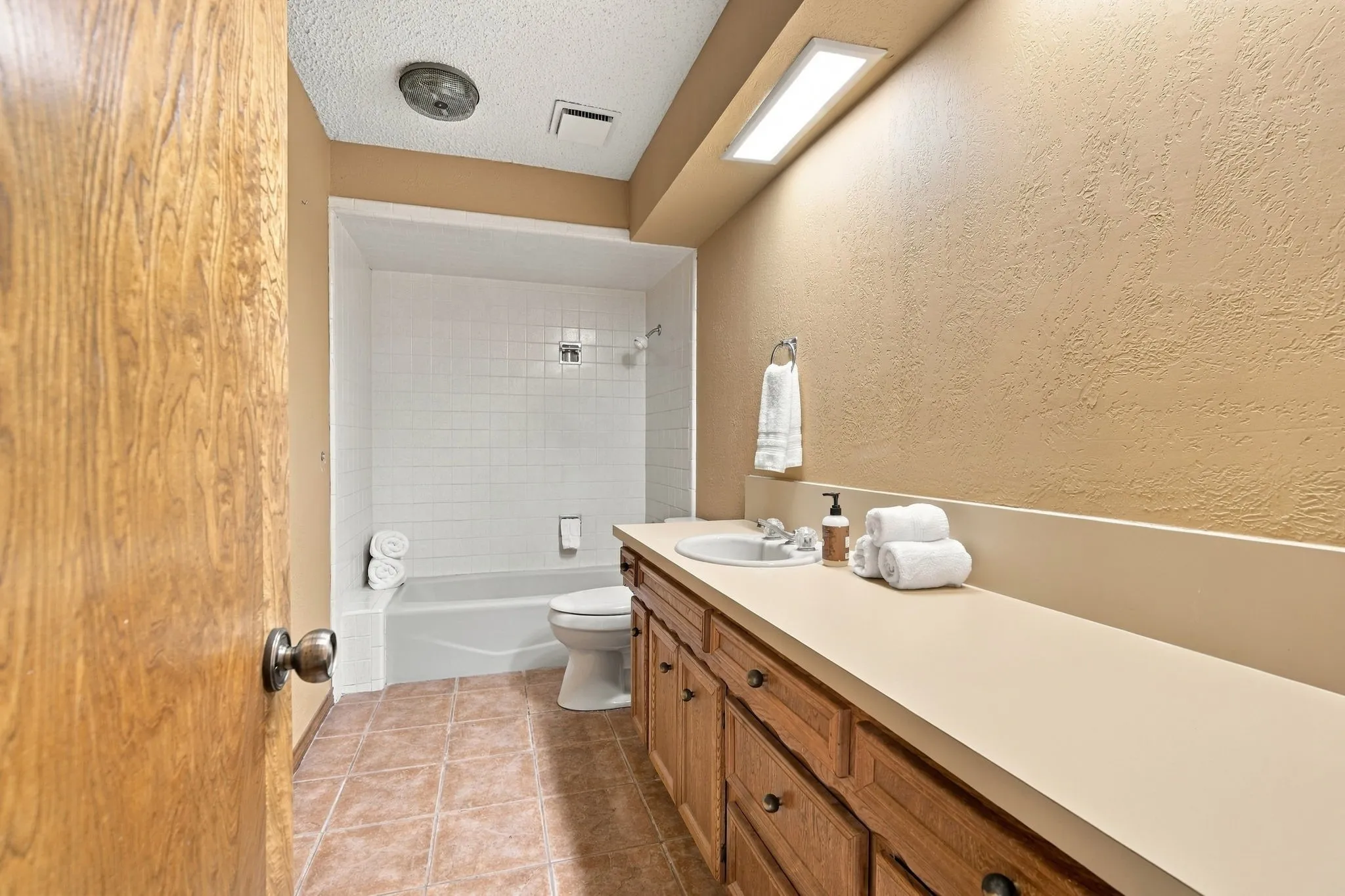 Full bath in hallway connecting to the smaller of the secondary bedrooms.