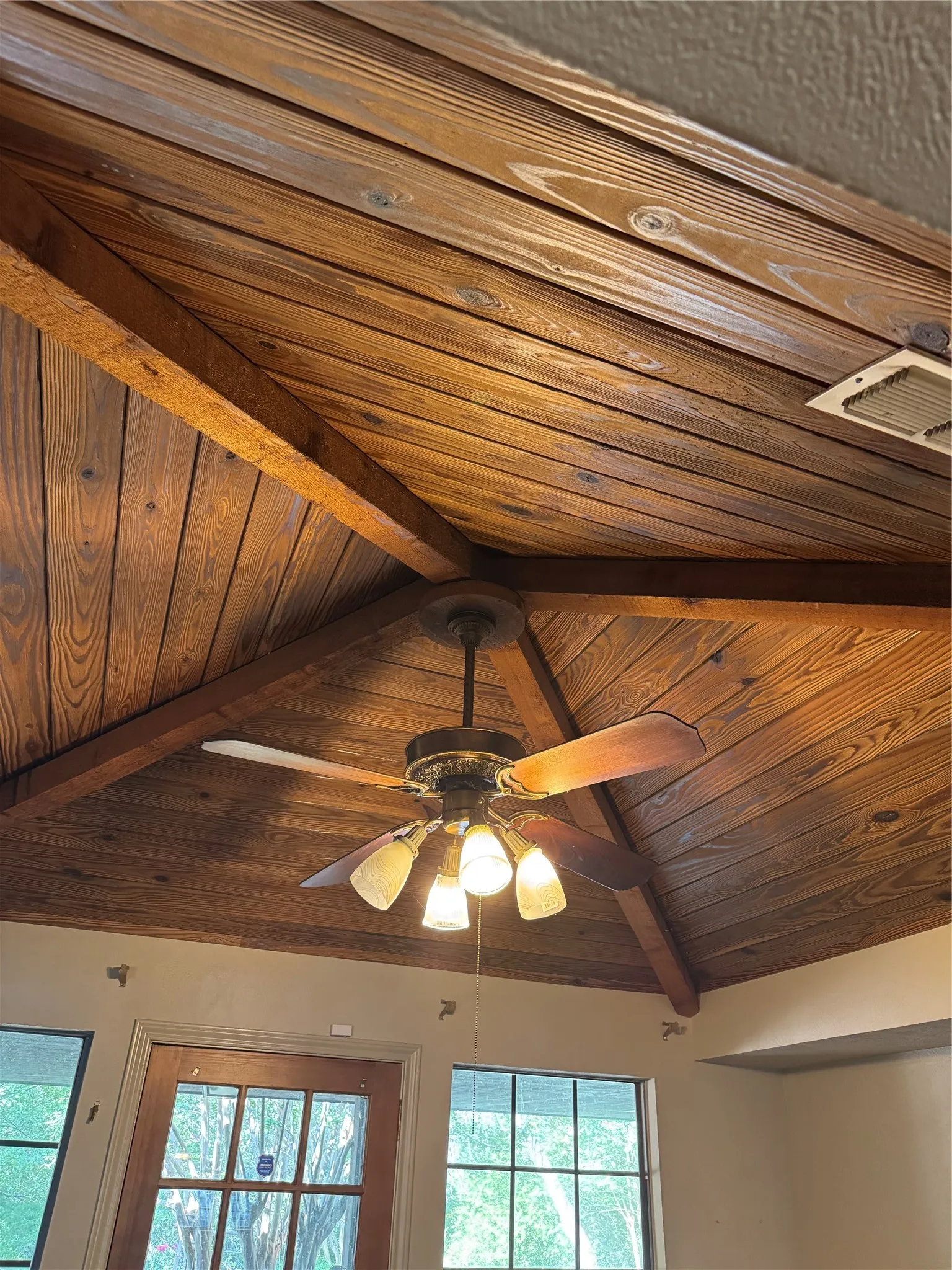 The tongue and groove ceiling in the breakfast room with solid wood beams