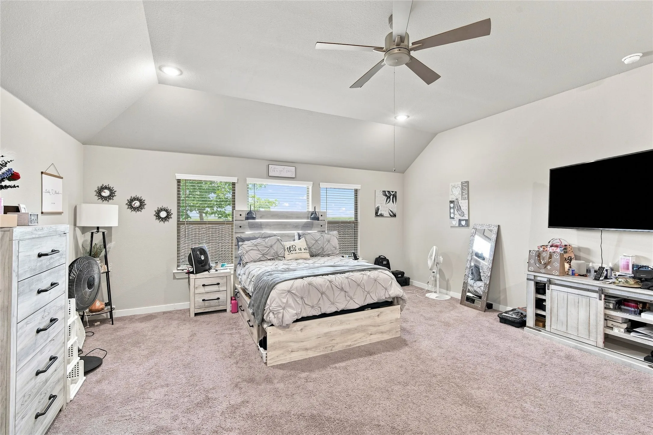 Vaulted ceiling with recessed lighting and a ceiling fan, multiple windows with blinds, and neutral wall tones