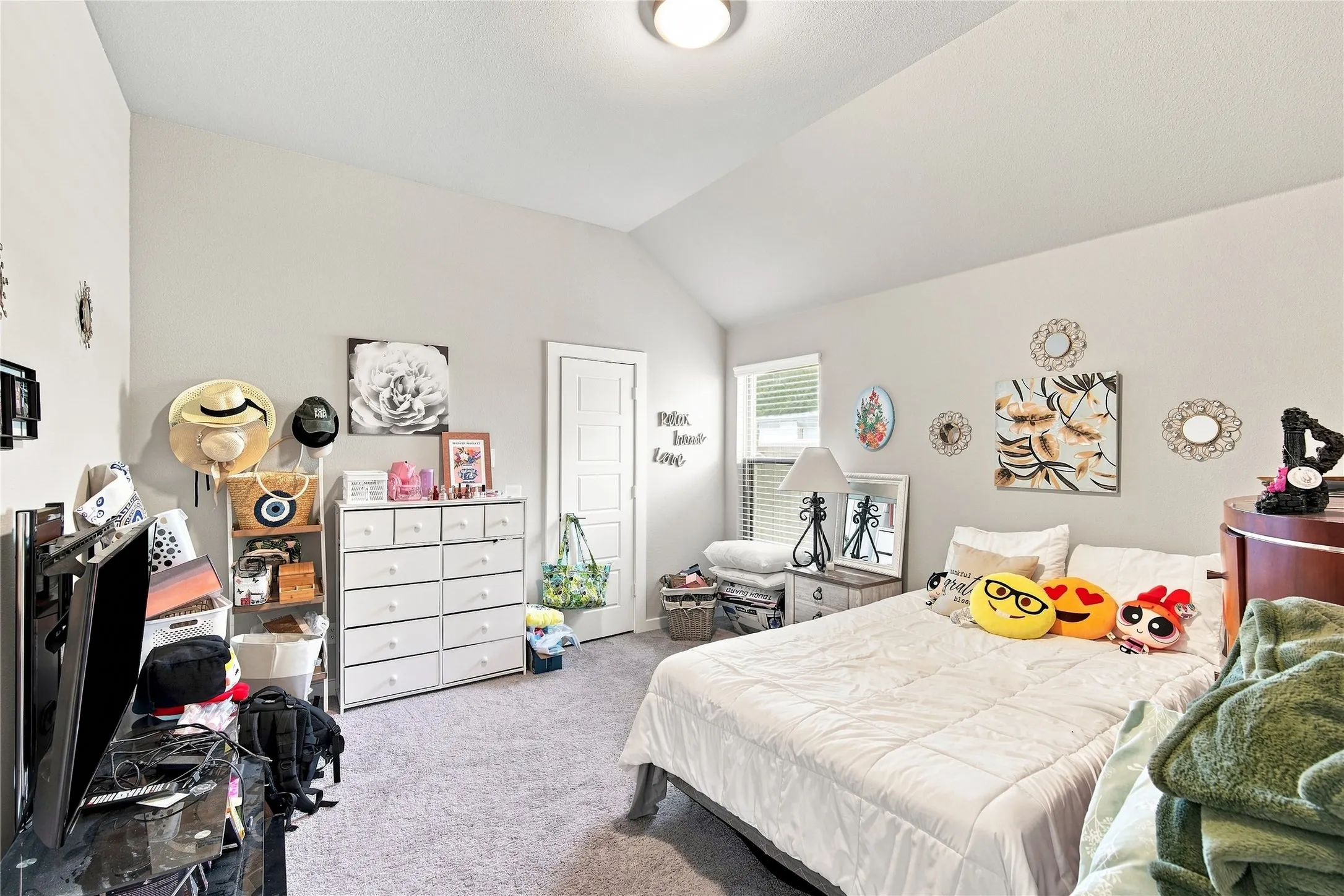 Vaulted ceiling, light-toned walls, recessed lighting, wall-to-wall carpeting, and a visible window