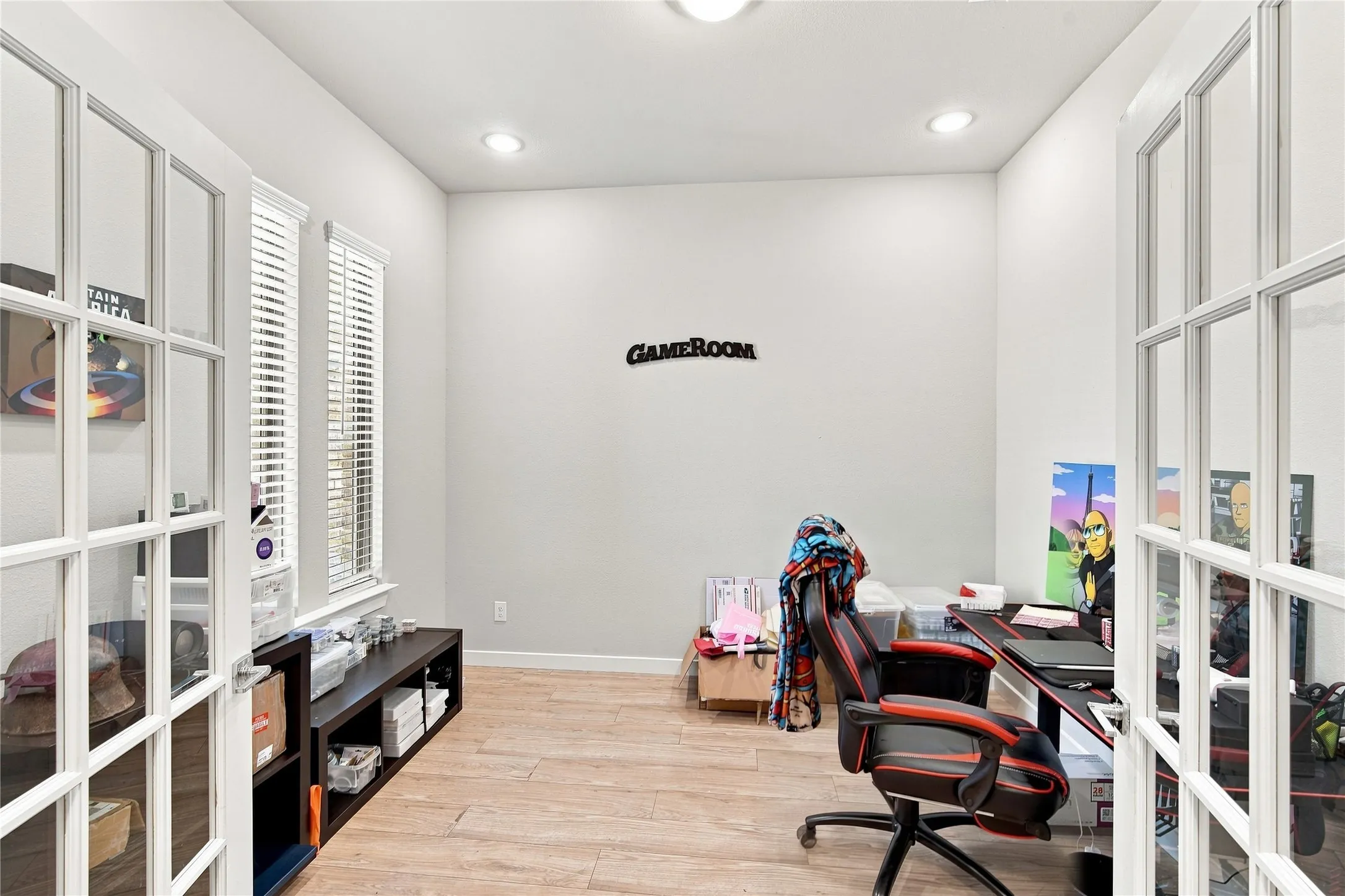 French doors with glass panes, two windows with blinds, wood-finish flooring, and recessed lighting